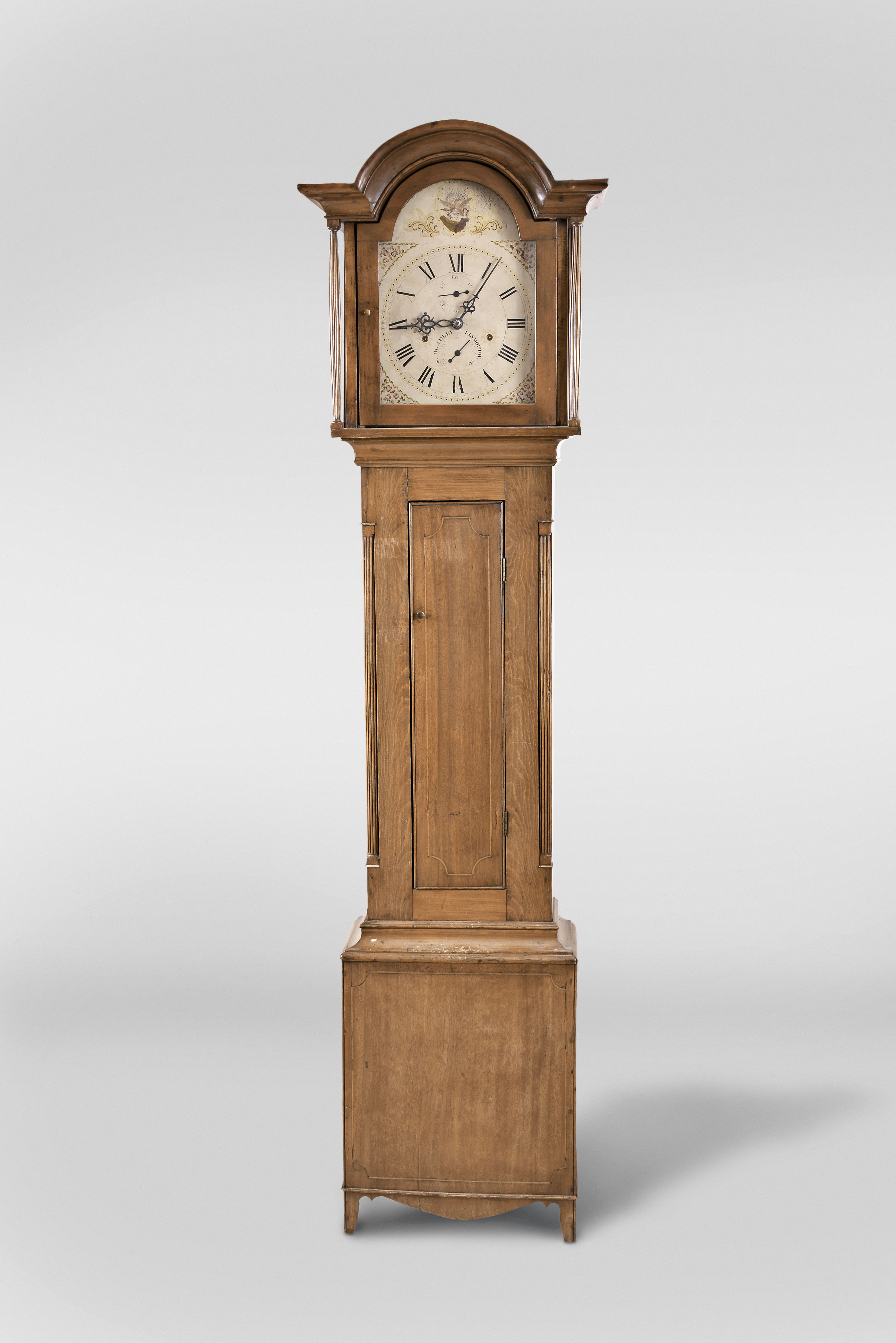 Silas Hoadley, Plymouth Conn., tall clock, 30 hour, time and strike, weight driven wooden works movement in an inlaid cherry case with fluted columns flanking hood and trunk doors and a painted wooden dial — Antique Clocks Price Guide