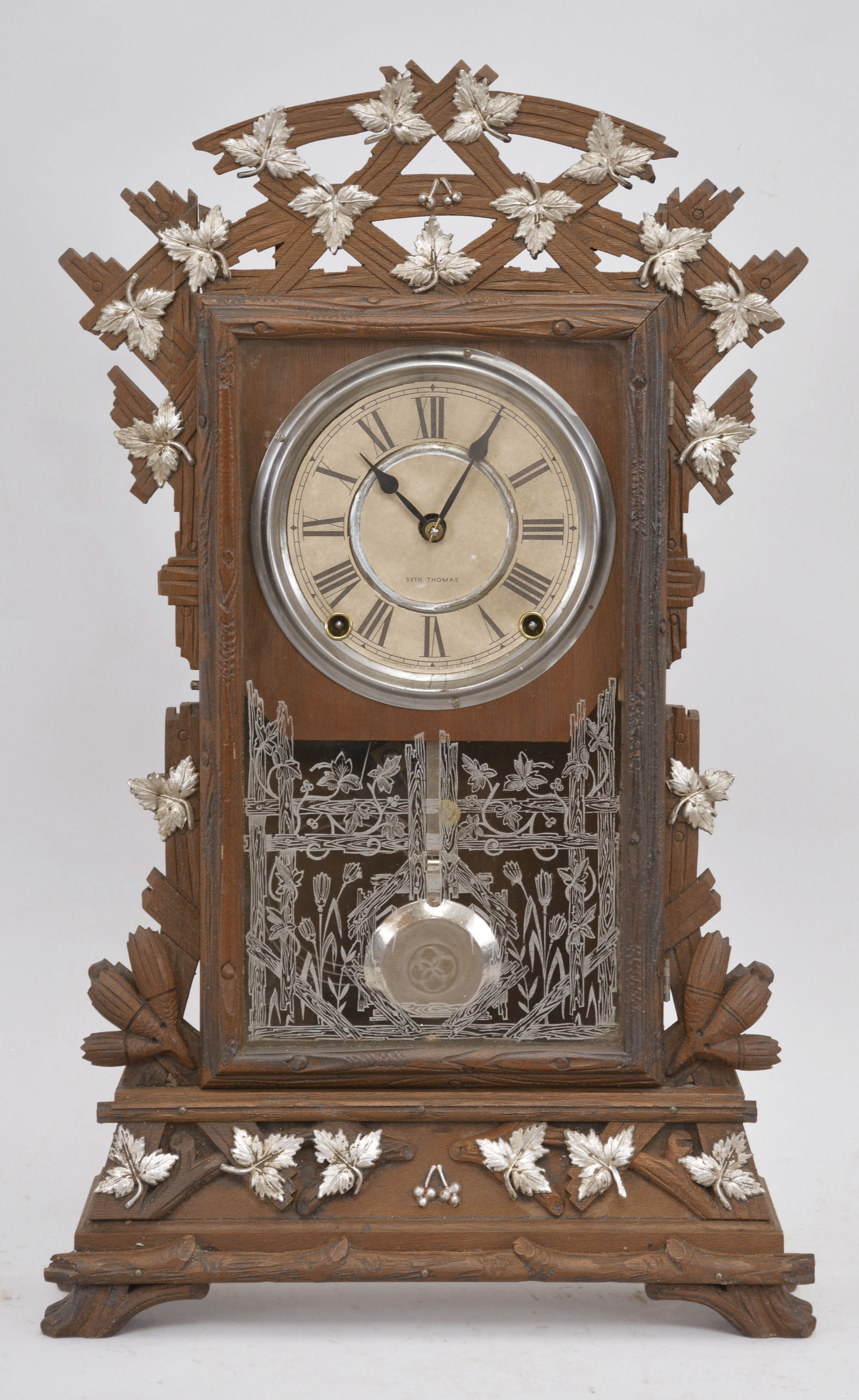 Seth Thomas Clock Co., Thomaston, Conn., "Santa Fe" city series mantel clock, 8 day, time and strike, spring driven movement in a carved walnut case with applied metal leaf decorations. — Antique Clocks Price Guide