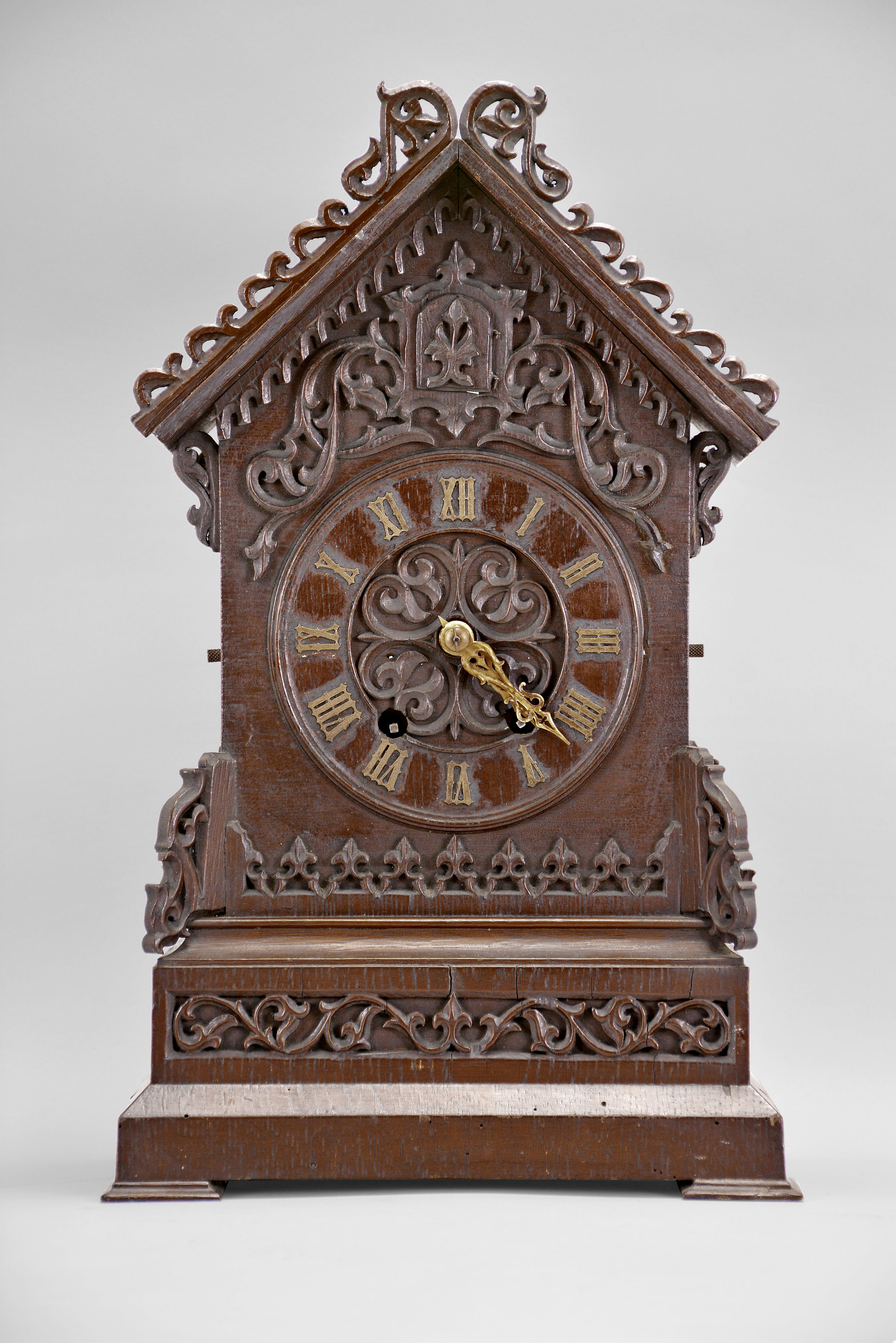 Black Forest, Germany, shelf cuckoo, 50 hour, time and strike with cuckoo bird, spring driven wood plate movement in a wood case with oak veneer on molded feet with stepped chamfered base, trimmed with carved fretwork and applied wood ornaments, bone hands and articulated cuckoo bird with carved feathers, applied Roman numeral dial. — Antique Clocks Price Guide