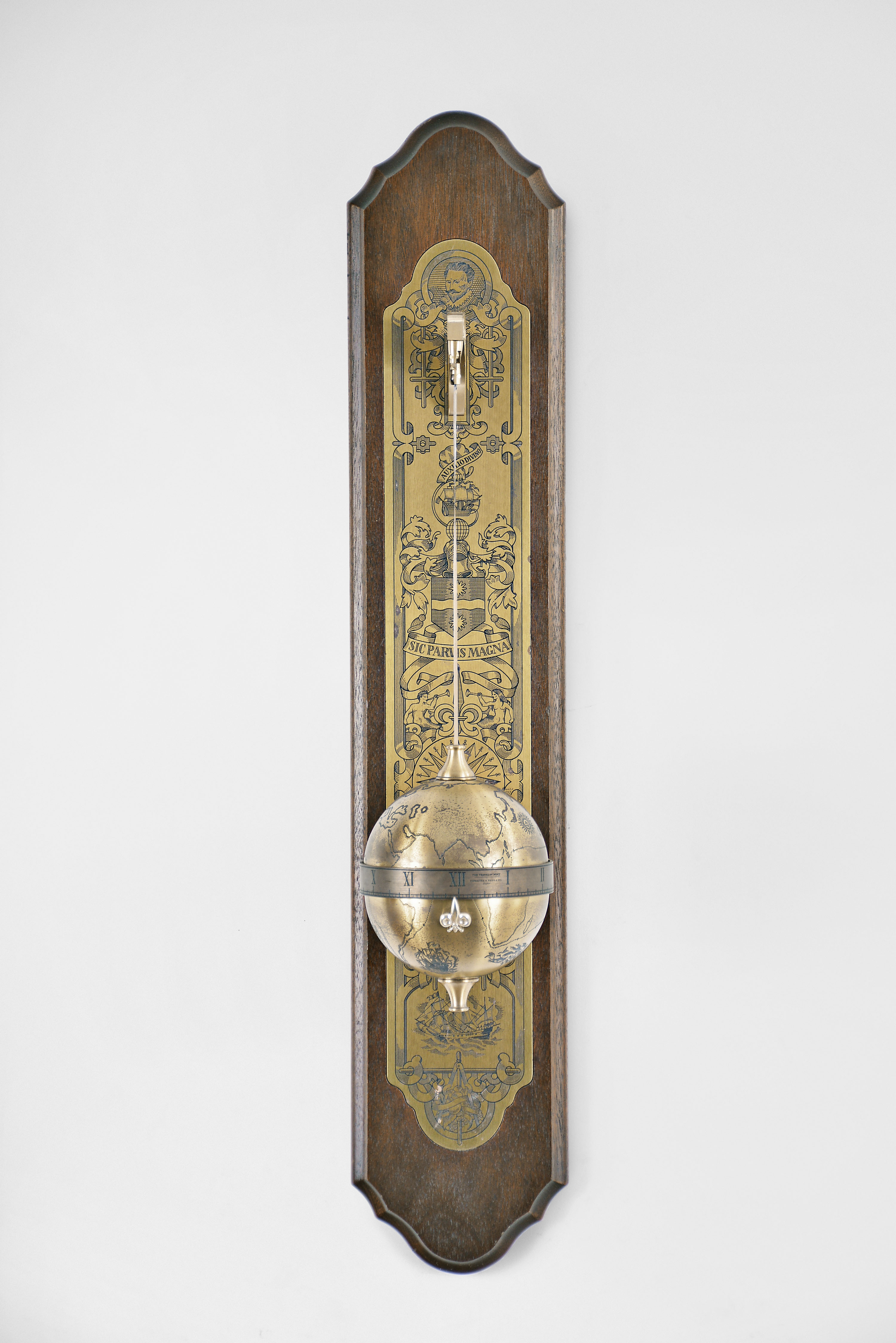 Thwaites &amp; Reed Ltd., England for The Franklin Mint, "Sir Francis Drake Falling Ball Clock", 8 day, time only, weight driven movement with annular time display in an engraved spherical case suspended from a cast brass bracket mounted to a wood back board with engraved brass plaque. — Antique Clocks Price Guide