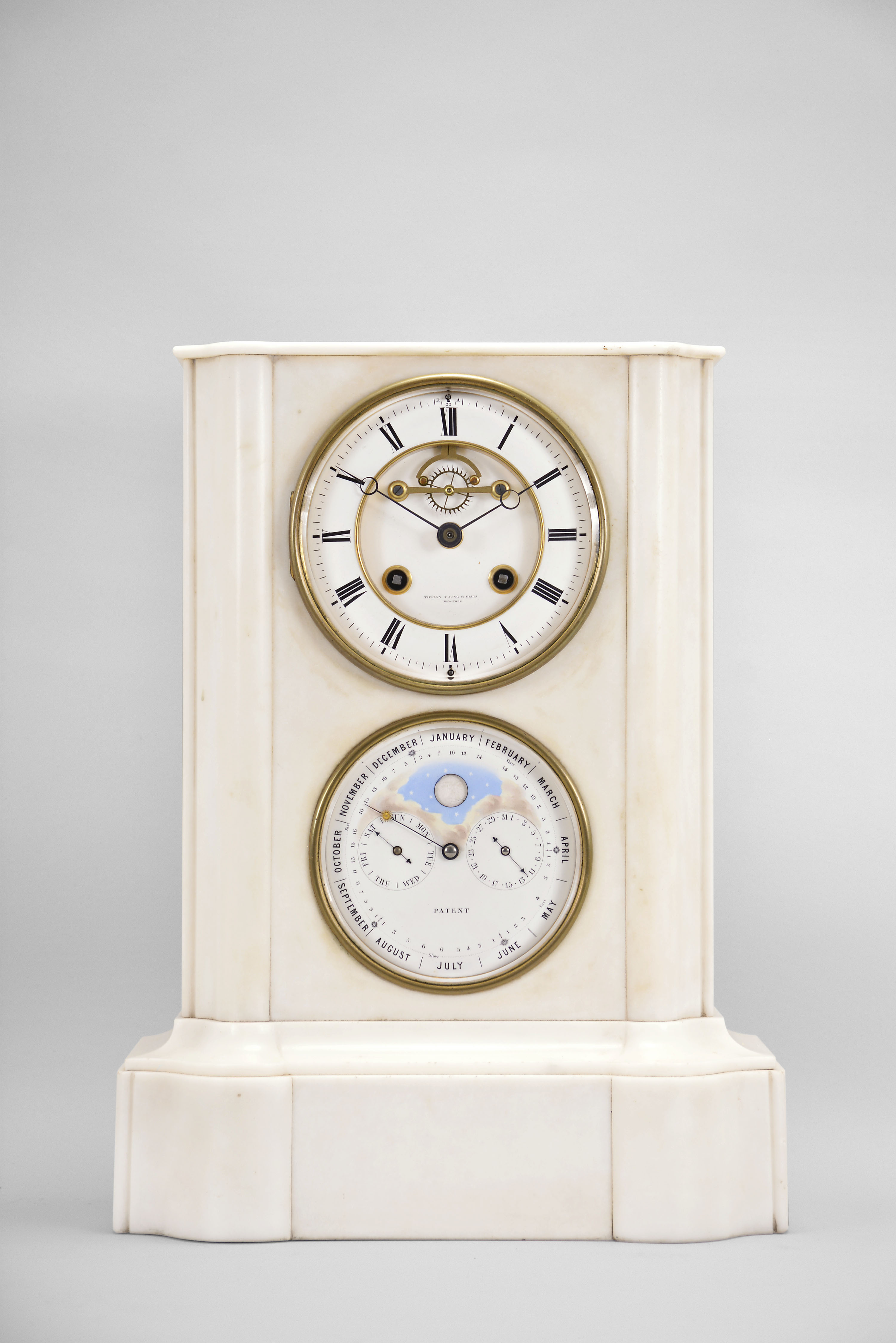 A. Brocot and Delettrez, Paris, France, for Tiffany, Young &amp; Ellis, New York, double dial calendar clock, 8 day, time and strike with rolling moon and calendar indicating day, date, and month perpetually, spring driven movement with visible Brocot escapement in a molded white marble case with white enamel dials, beveled glasses, and blued steel hands. — Antique Clocks Price Guide