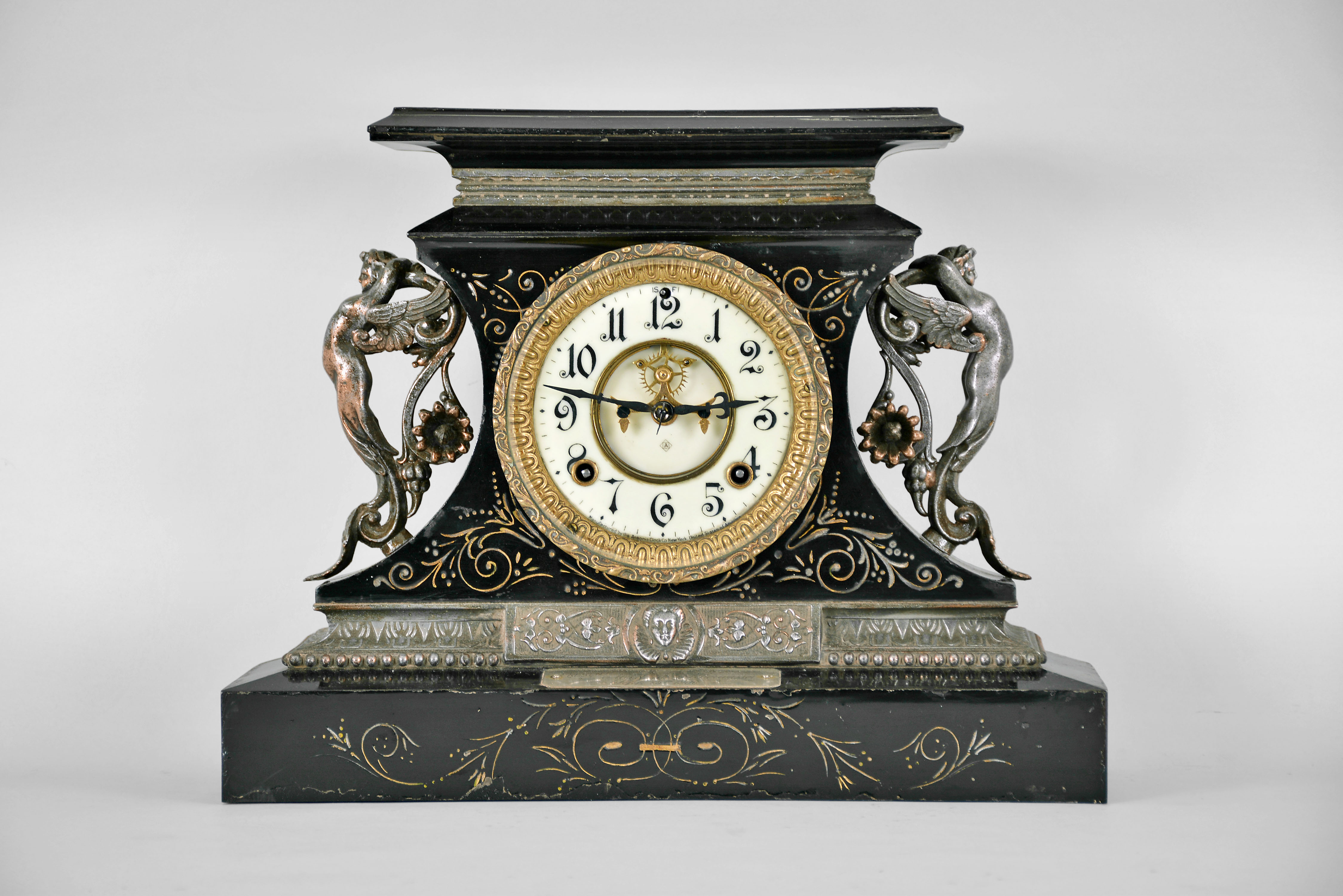 Ansonia Clock Co., New York, "Rosalind" 8 day, time and spring brass movement cast iron black mantel clock with visible escapement. A plaque on the case reads: "Presented by Mr. &amp; Mrs. B. Uberwasser", Sept. 15th, 1906 ". — Antique Clocks Price Guide