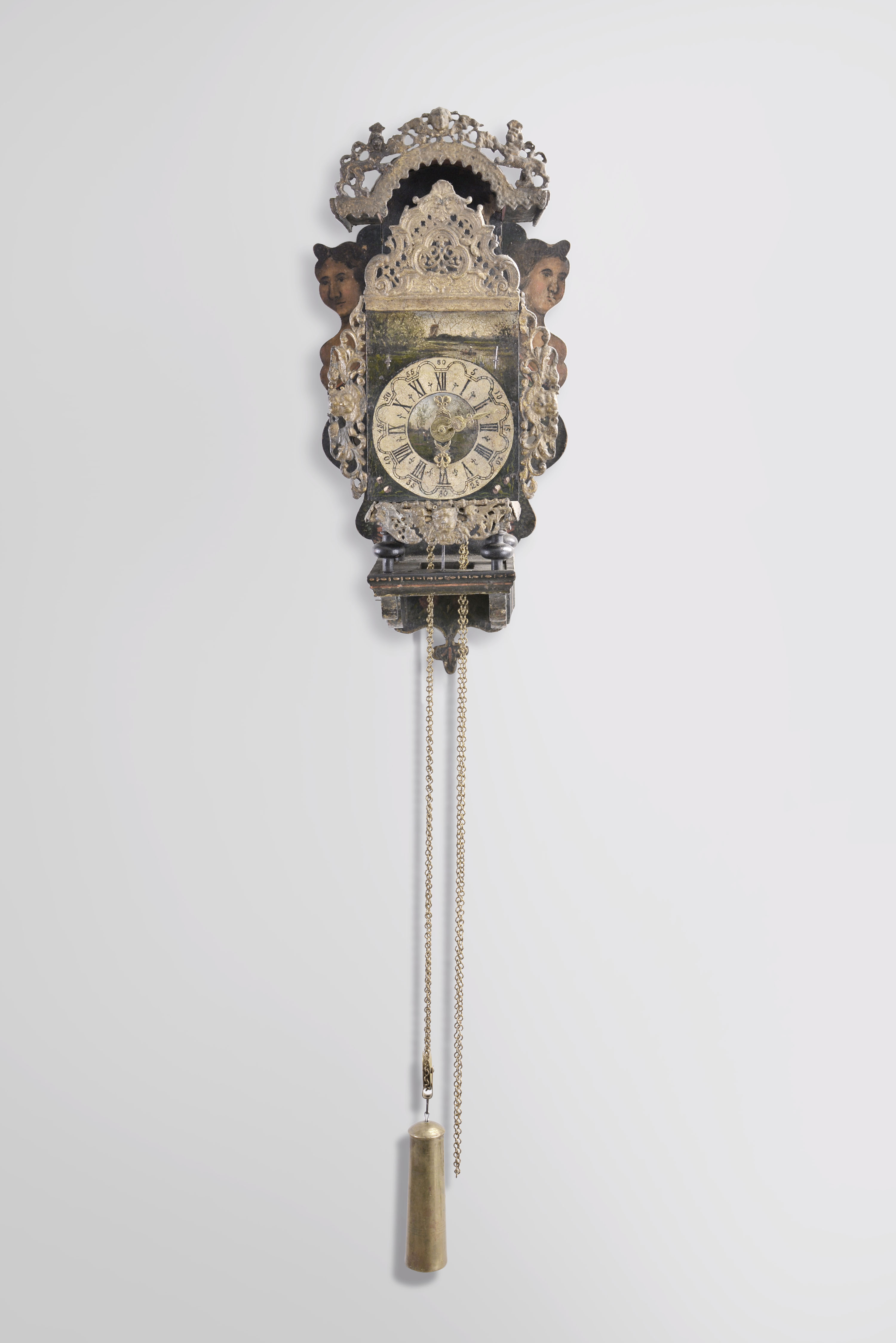 Netherlands, Frisian stoelklok, 30 hour, time and strike with alarm, weight driven movement with verge escapement, the clock resting on a polychrome painted shelf with mermaids and painted floral decoration, lead ornaments throughout, Roman numeral painted, arcaded dial with landscape painting with windmills above, and pierced brass hands. — Antique Clocks Price Guide