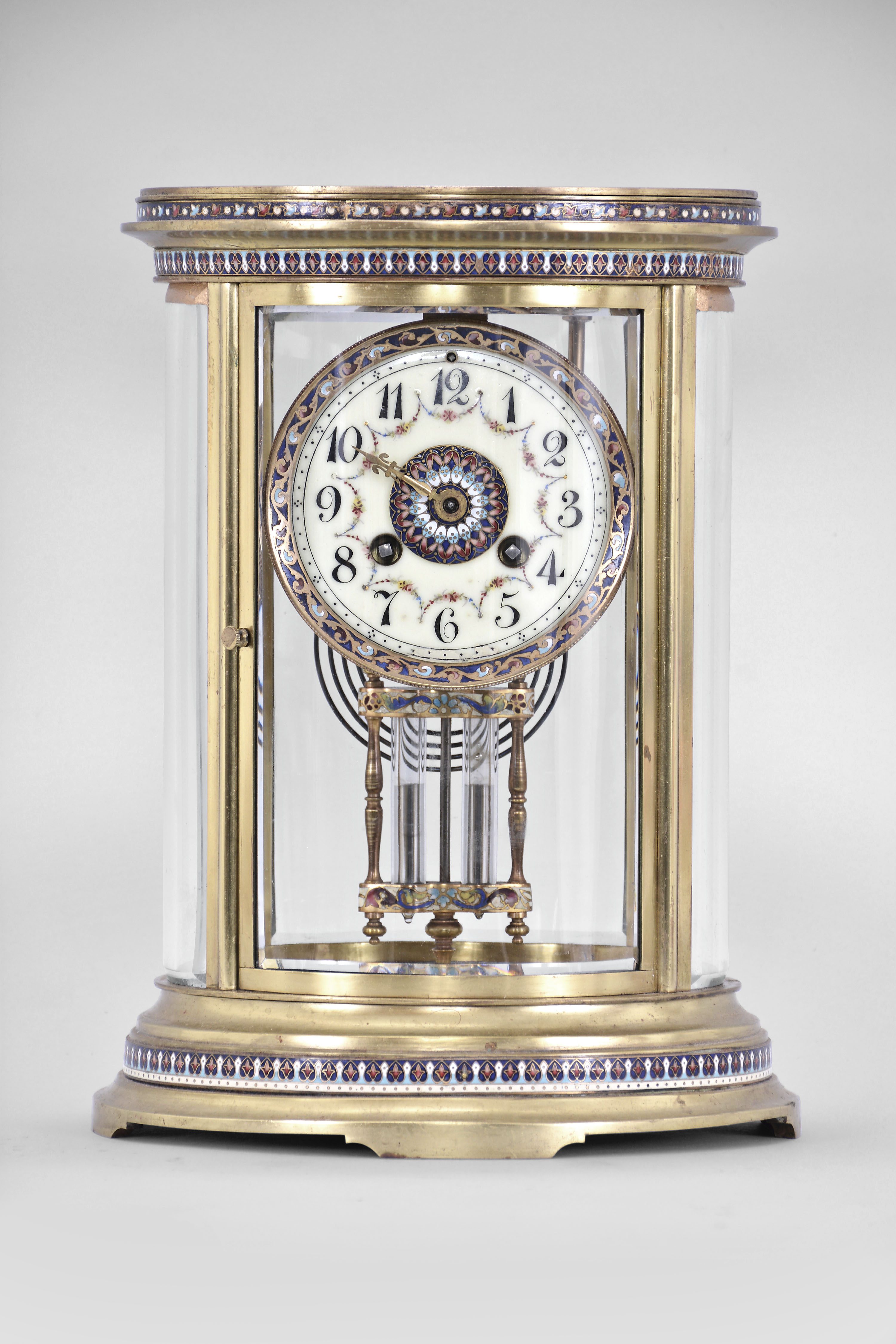 S. Marti &amp; Cie, Paris, France, oval crystal regulator, 8 day, time and strike, spring driven pendule de Paris movement in a gilt brass case with four curved beveled glasses, cloisonne trim in bands around the case top and bottom, dial, and on the frame of the compensating pendulum, cream colored enamel dial with Arabic numerals, gilt hands, and double-vial pendulum. — Antique Clocks Price Guide