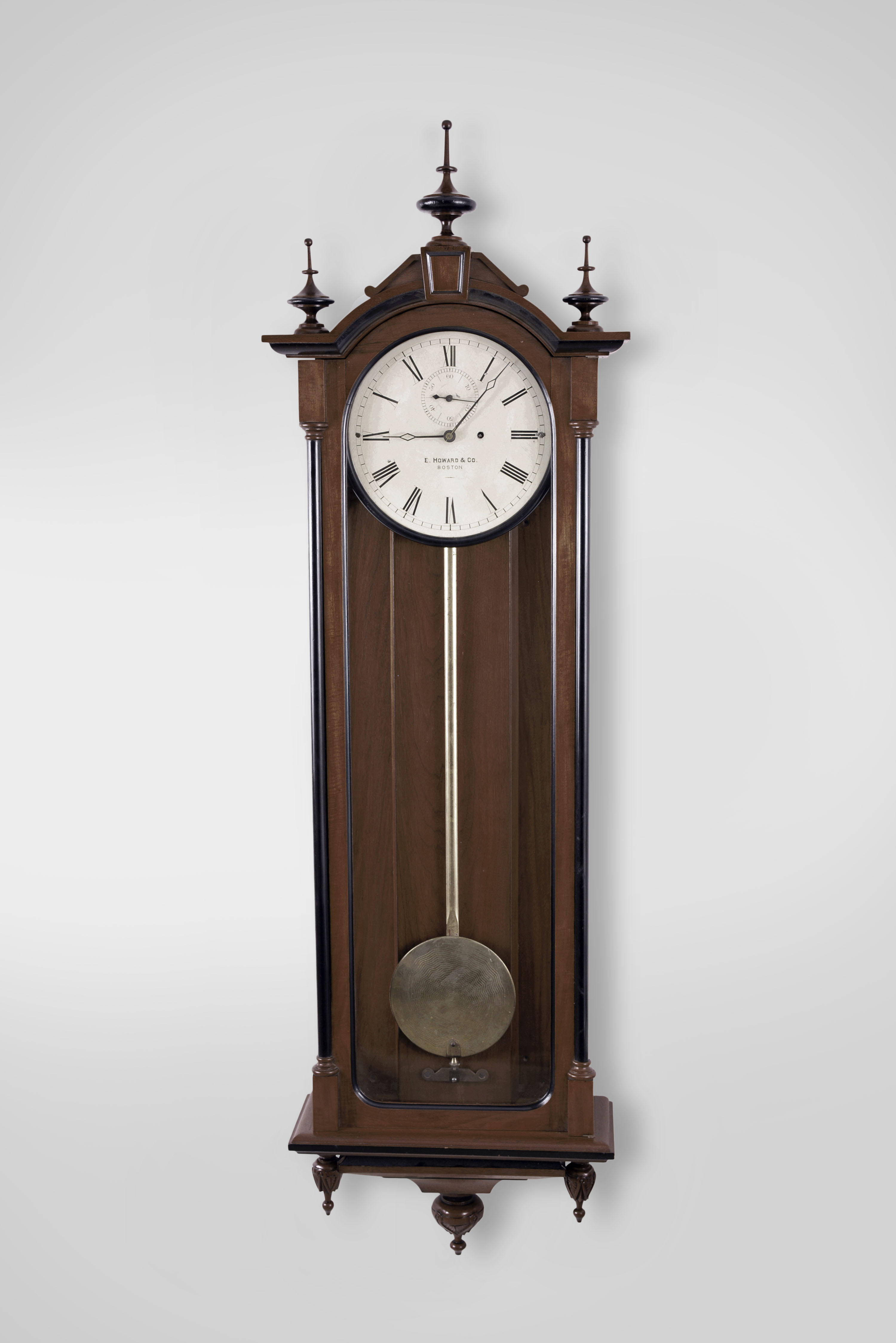 E. Howard &amp; Co., Boston, Mass., "No. 71 Regulator" wall clock, 8 day, time only, weight driven movement with deadbeat escapement in a walnut case with ebonized trim, gilded wooden pendulum rod, damascened pendulum bob, painted metal dial and seconds bit — Antique Clocks Price Guide
