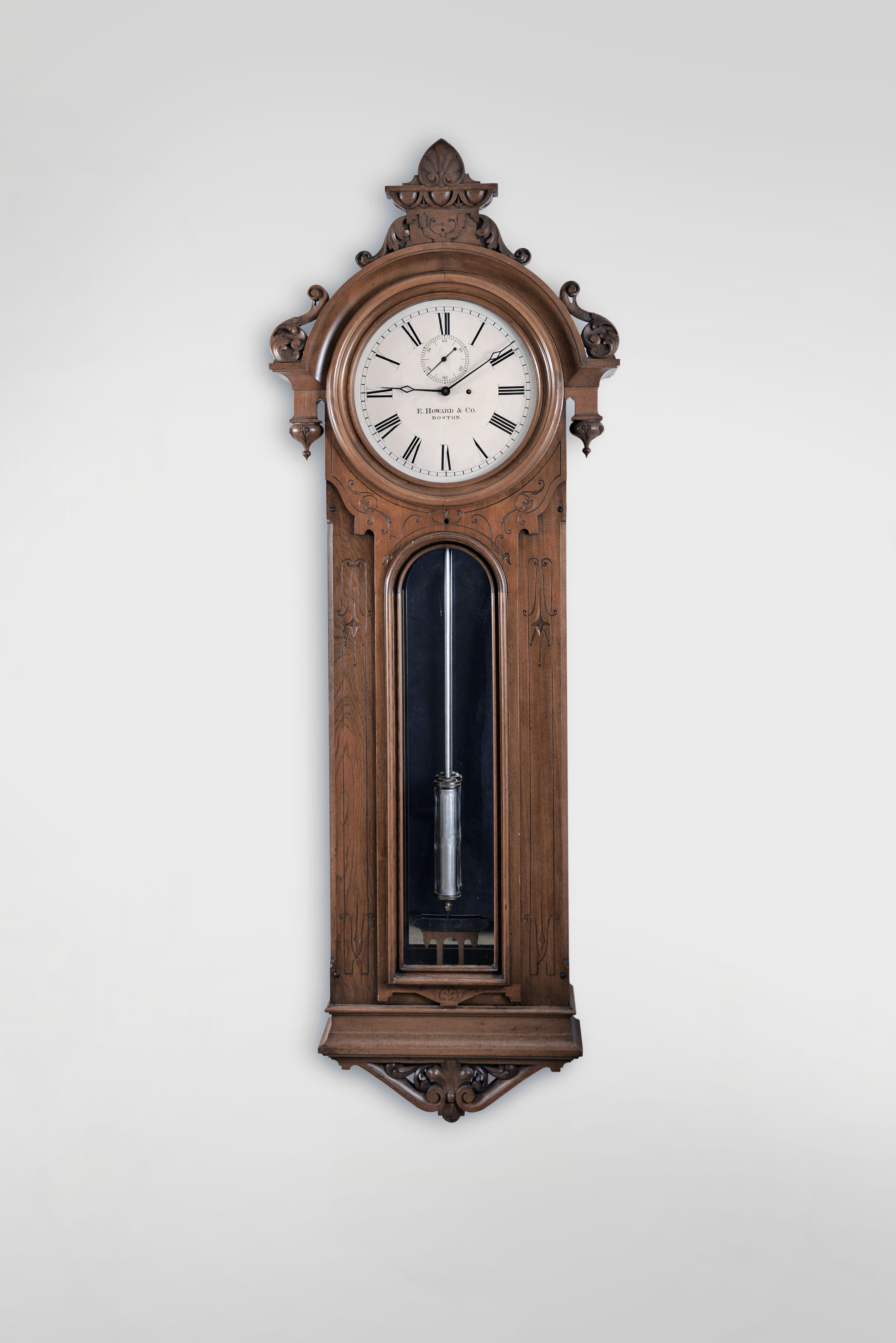 E. Howard &amp; Co., Boston, Mass., "No. 36 Regulator", 8 day, time only, weight driven movement with Graham deadbeat escapement, meter long pendulum with loaded glass jar in a carved walnut case with mirrored back and painted metal dial. — Antique Clocks Price Guide