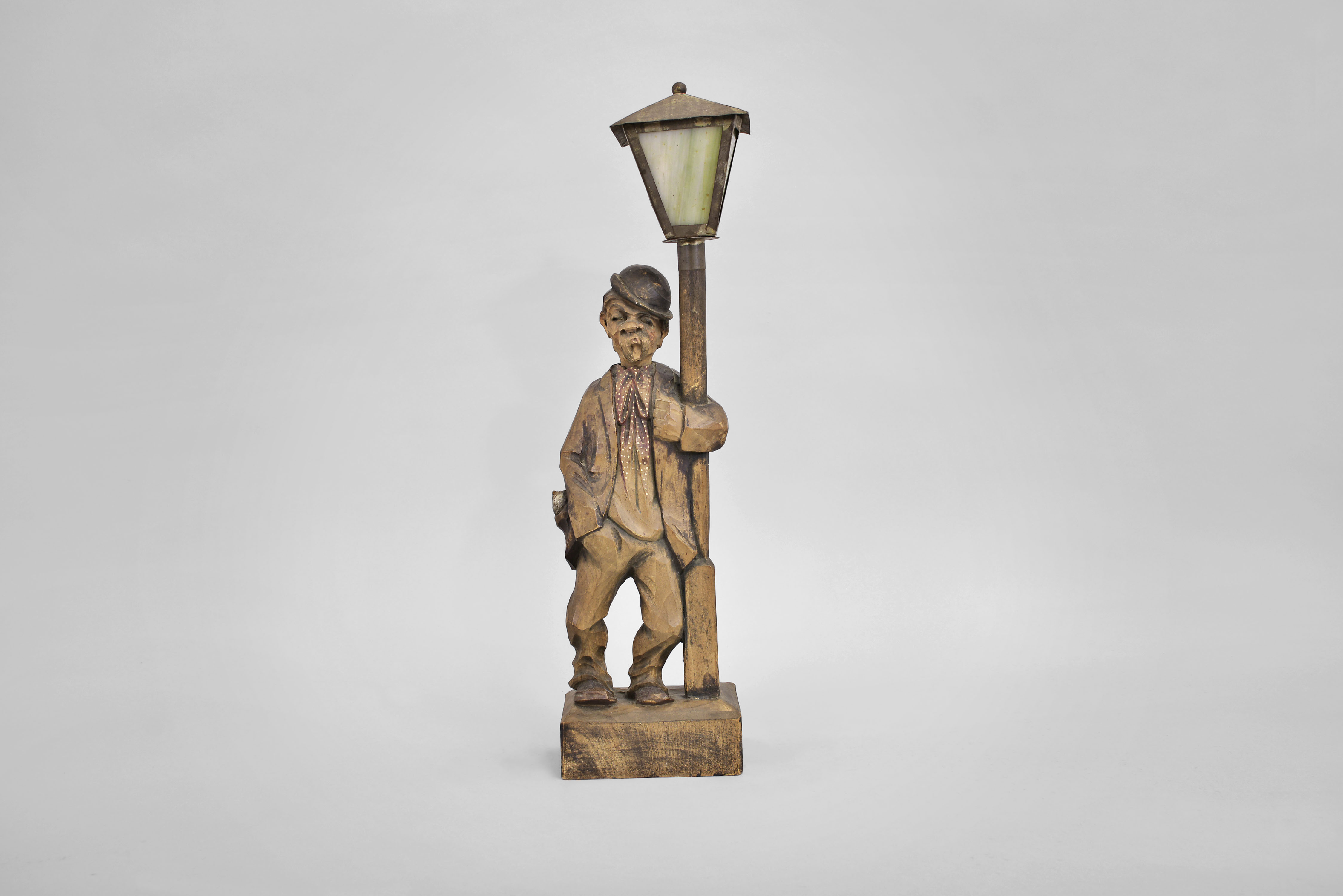 Karl Griesbaum, Triberg, Germany, "Drunkard" whistling figure, spring driven brass movement driving bellows, cam-controlled whistle, and head-turning motion enclosed in hand carved wooden figure depicting an intoxicated man wearing an askew bowler hat who leans on a lamp post for support as he whistles a tune. — Antique Clocks Price Guide