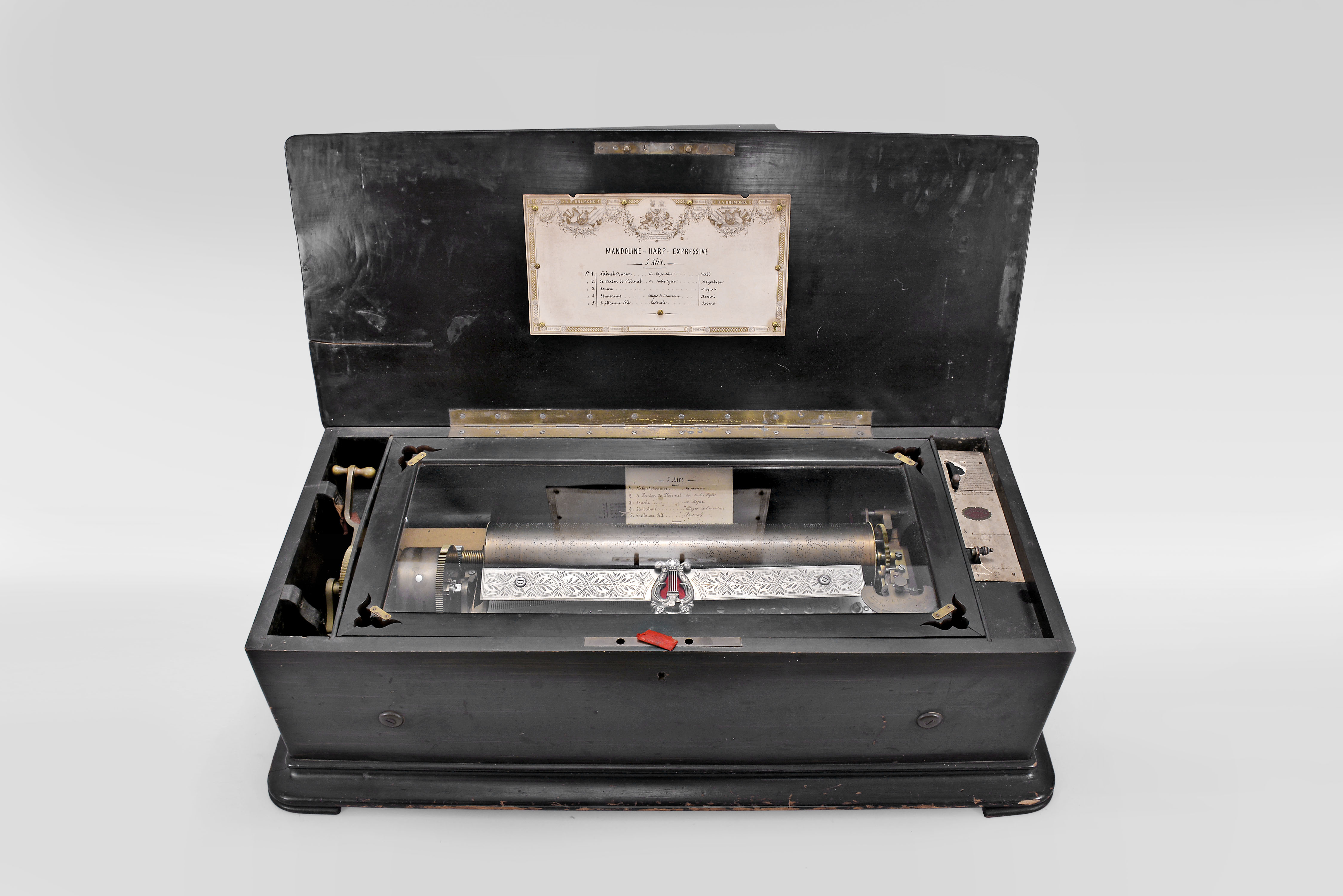 B.A. Bremond, Geneva, Switzerland, 5 tunes with a 17 inch cylinder playing on a three-piece comb using two mainsprings in a dark hardwood case with paper tune card under the lid and engraved tune card within the box, paper label with operating instructions in French, and a handwritten bill for the sale or upgrade of the machine signed by B.A. Bremond, serial number 18216 — Antique Clocks Price Guide