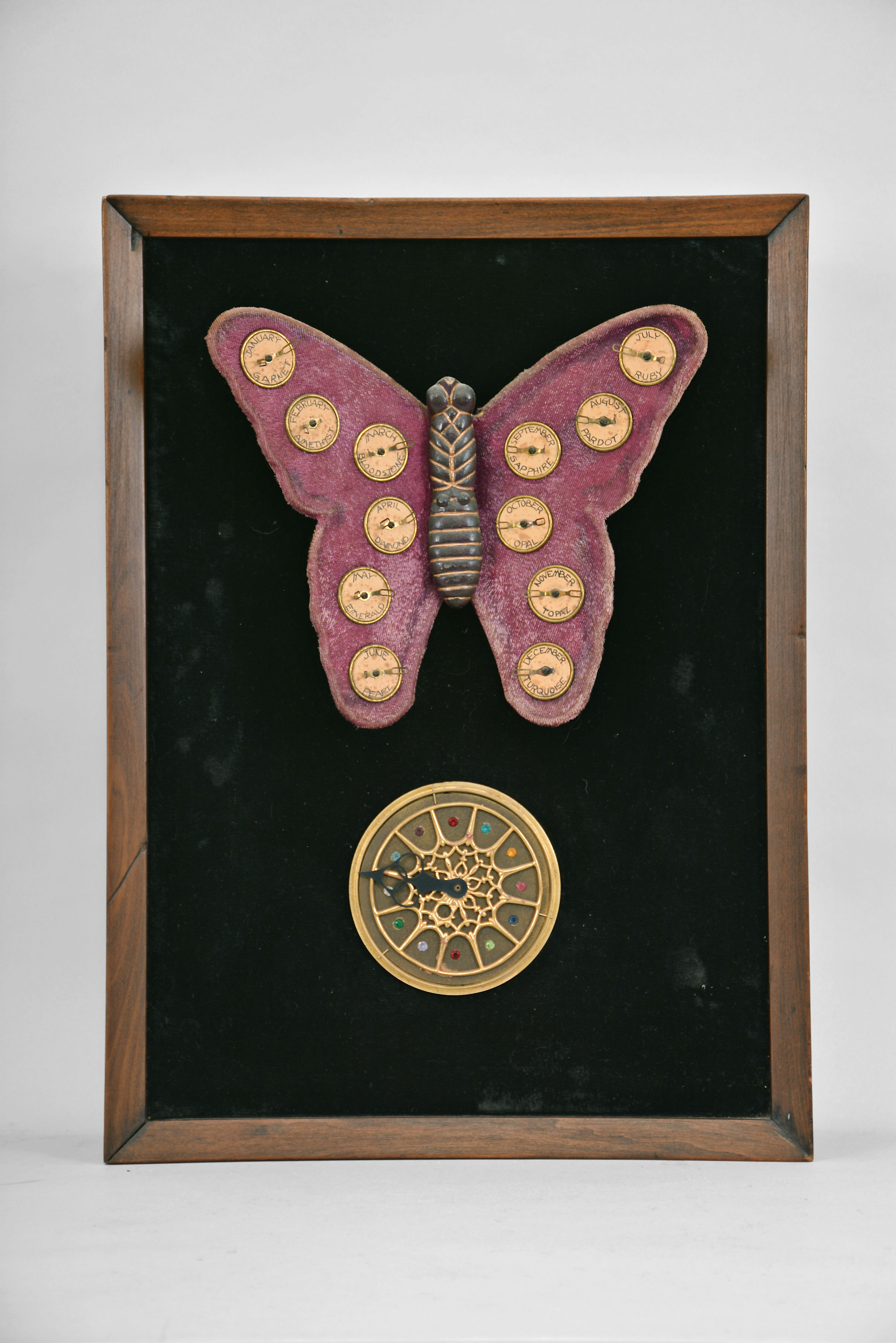The Attracto Company, Philadelphia, Penn., jeweler's advertising display, spring driven pendulum movement in a wood case powering a velvet covered butterfly with moving wings, 12 finger ring holders on the wings corresponding to the birthstone for each month. — Antique Clocks Price Guide