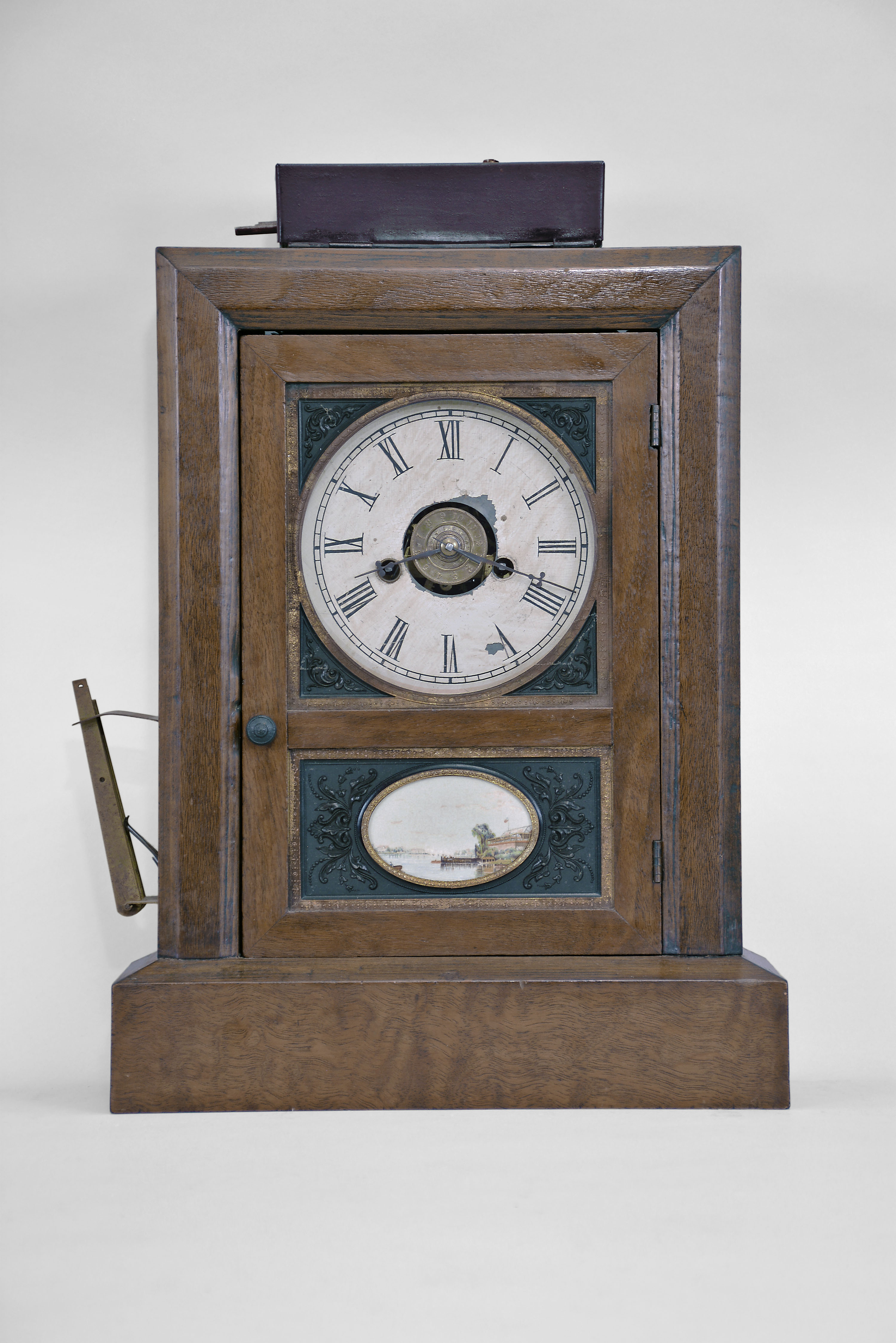 Jerome &amp; Co., New Haven, Conn., cottage clock, 30-hour, time and strike with lamp-lighting burglar alarm, spring driven movement in a mahogany veneered case with decorative thermoplastic inserts in upper and lower parts of door, painted metal dial, and steel hands. — Antique Clocks Price Guide