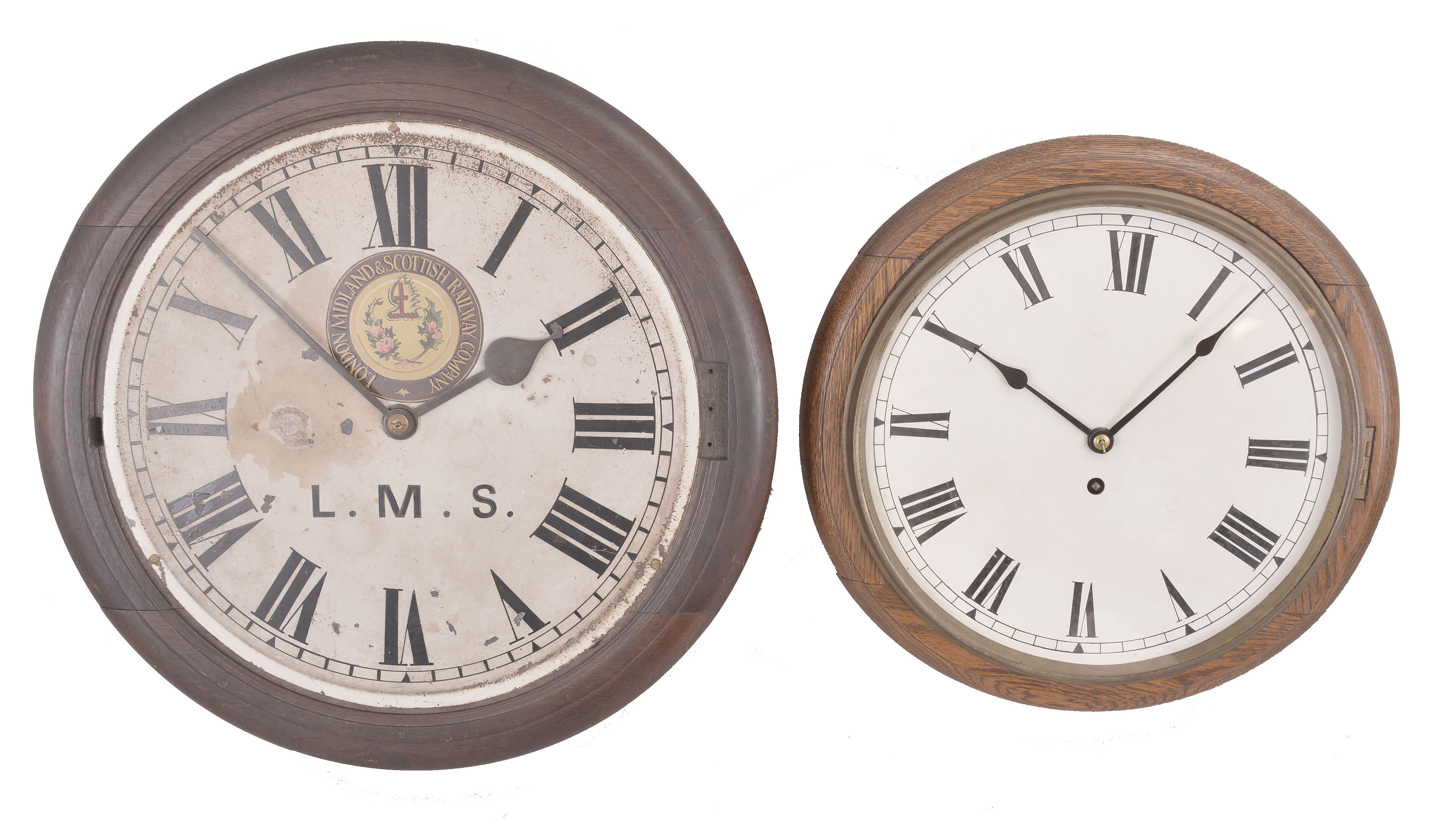 Clocks- 2 (Two) English Dial Clocks: (1) Coventry / Astral, England, dial clock, 8 day, time only, spring driven fusee movement in a walnut case with painted metal dial featuring the seal of the "London Midland &amp; Scottish Railway Company", c1925; (2) England, dial clock, 8 day, spring driven fusee movement in a wood case with oak bezel, painted metal dial, c1915. — Antique Clocks Price Guide