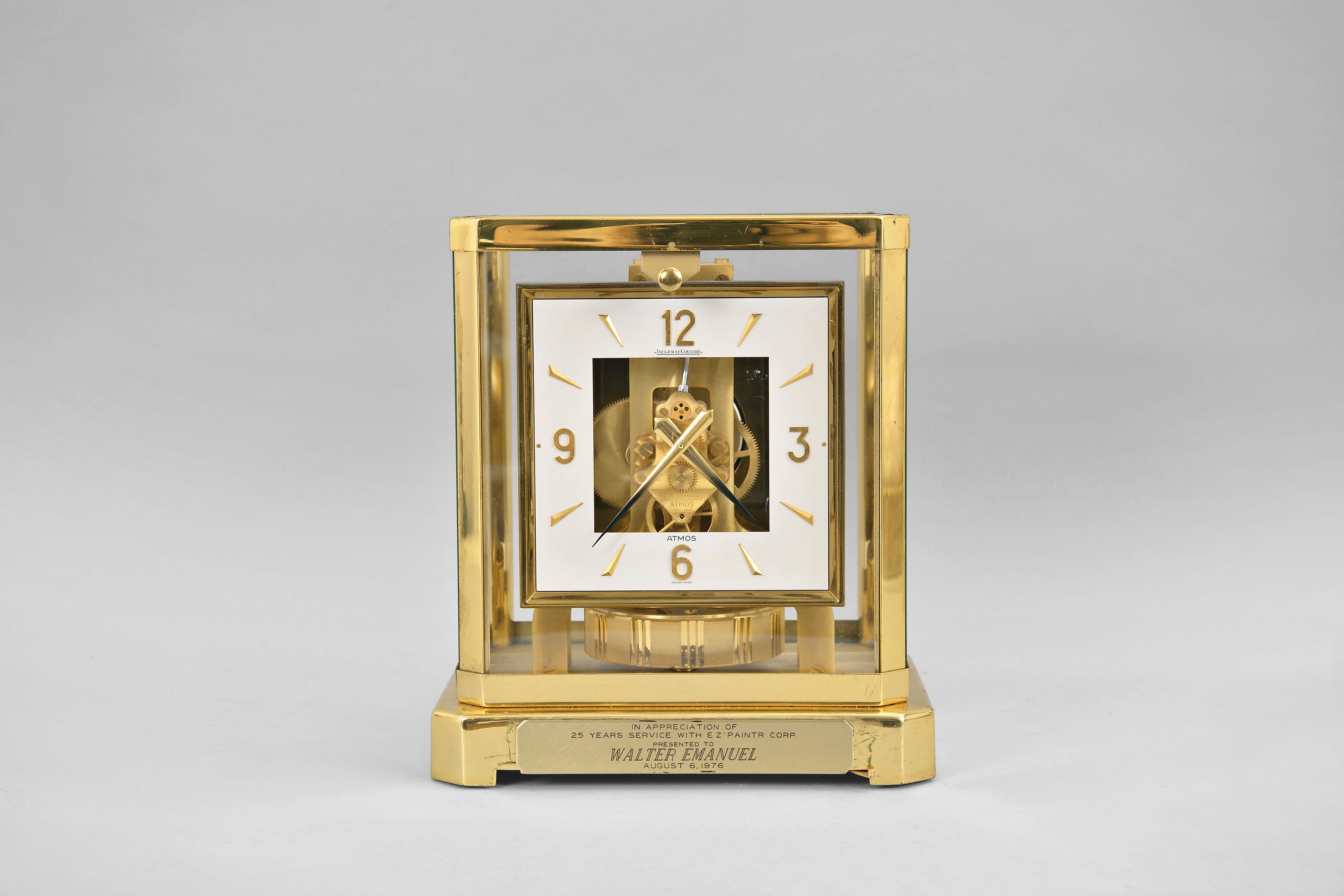 Jaeger-LeCoultre, Switzerland, "Atmos" clock, caliber 528, 15 jewel movement, gilt torsion pendulum, square white dial with applied gilt Arabic numerals and arrow markers, gilt hands, all within a glazed rectangular case with removable front panel, serial number 434180. — Antique Clocks Price Guide