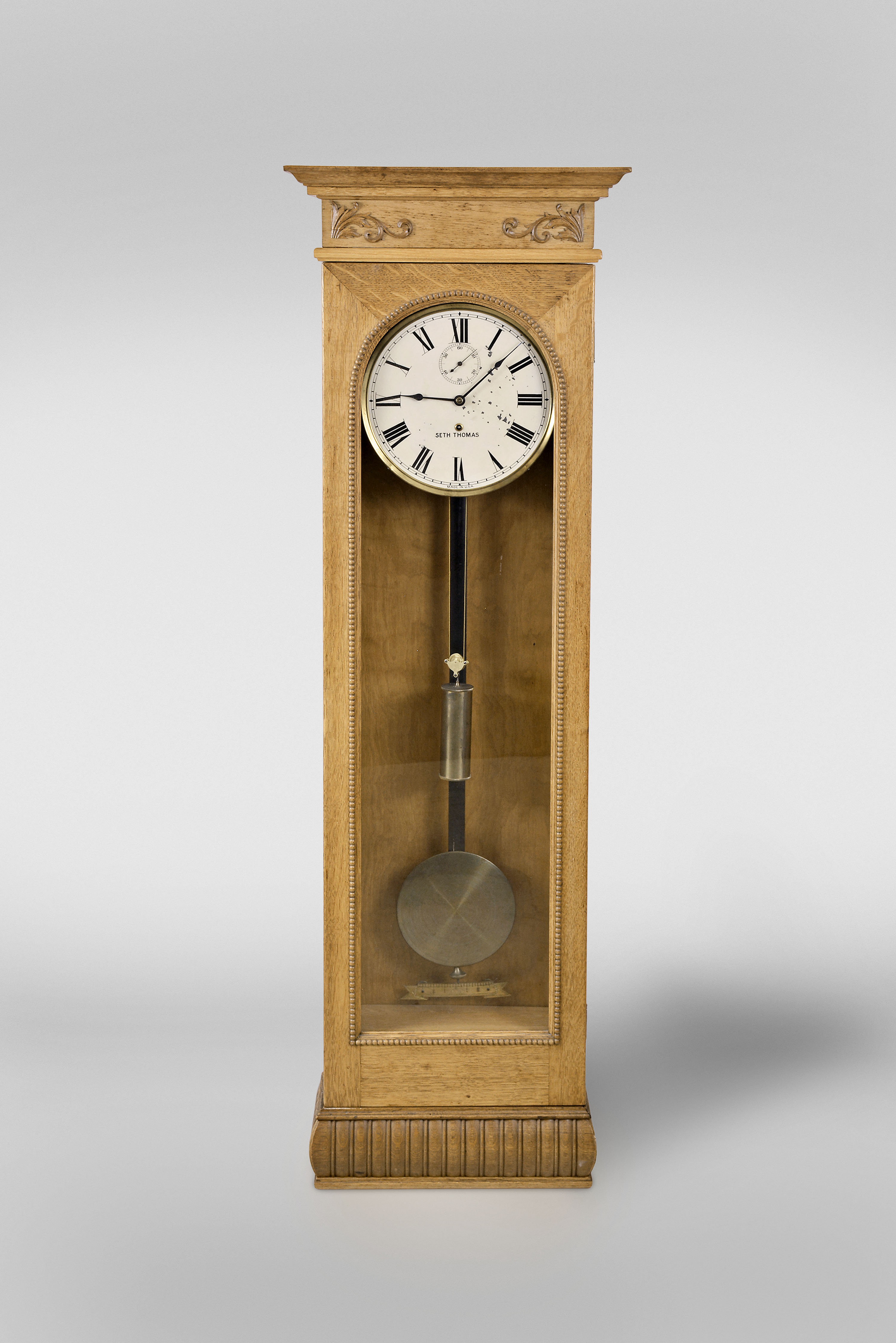 Seth Thomas Clock Co., Thomaston, Conn., regulator movement in an associated custom oak case with meter length pendulum and brass bob, painted metal dial and seconds bit — Antique Clocks Price Guide