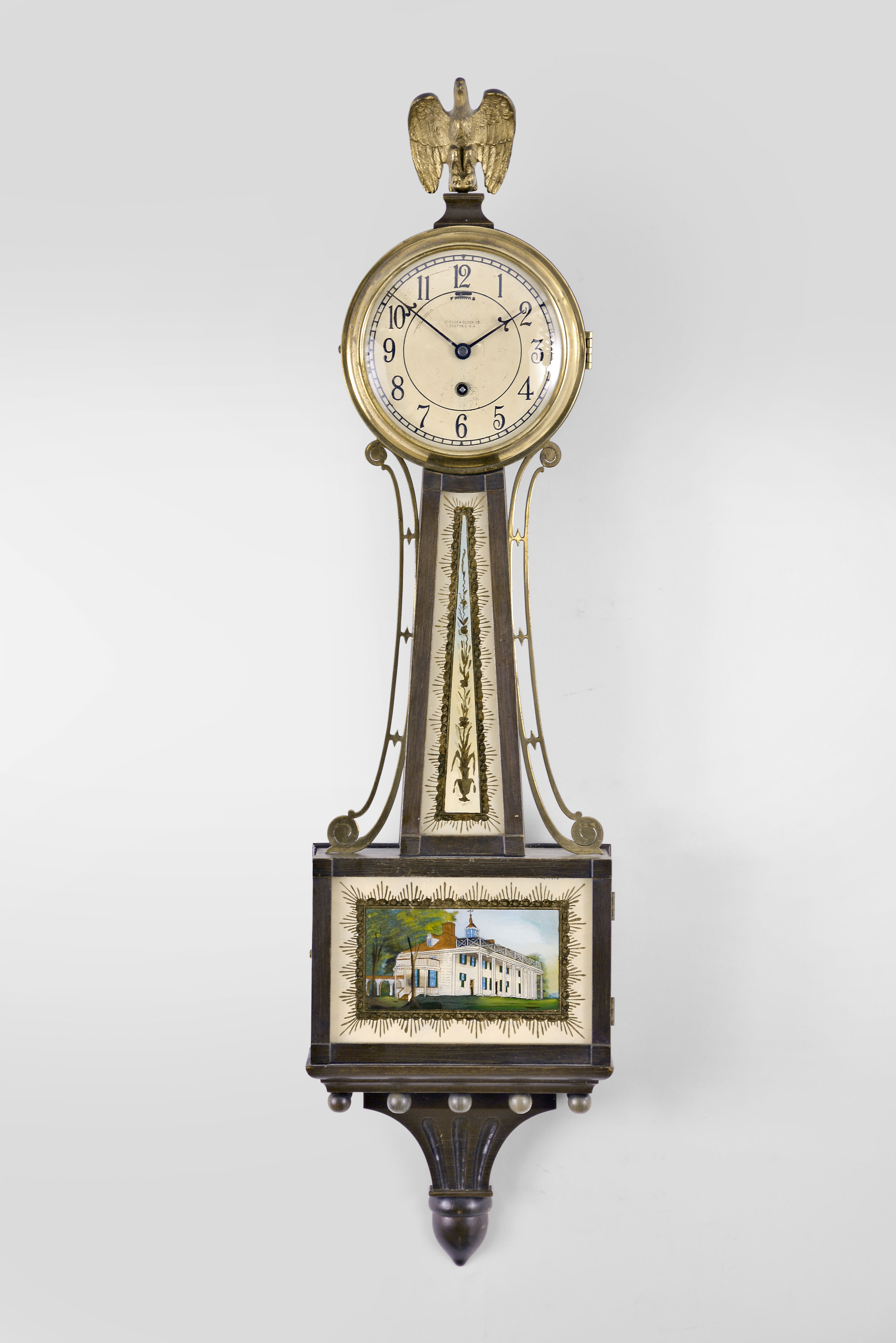 Chelsea Clock Co., Boston, Mass., "3/4 Willard Banjo" timepiece, 8 day, time only, spring driven balance wheel movement with lever escapement in a mahogany case with back-painted glasses featuring Mt. Vernon, painted metal dial, and blued steel hands. — Antique Clocks Price Guide