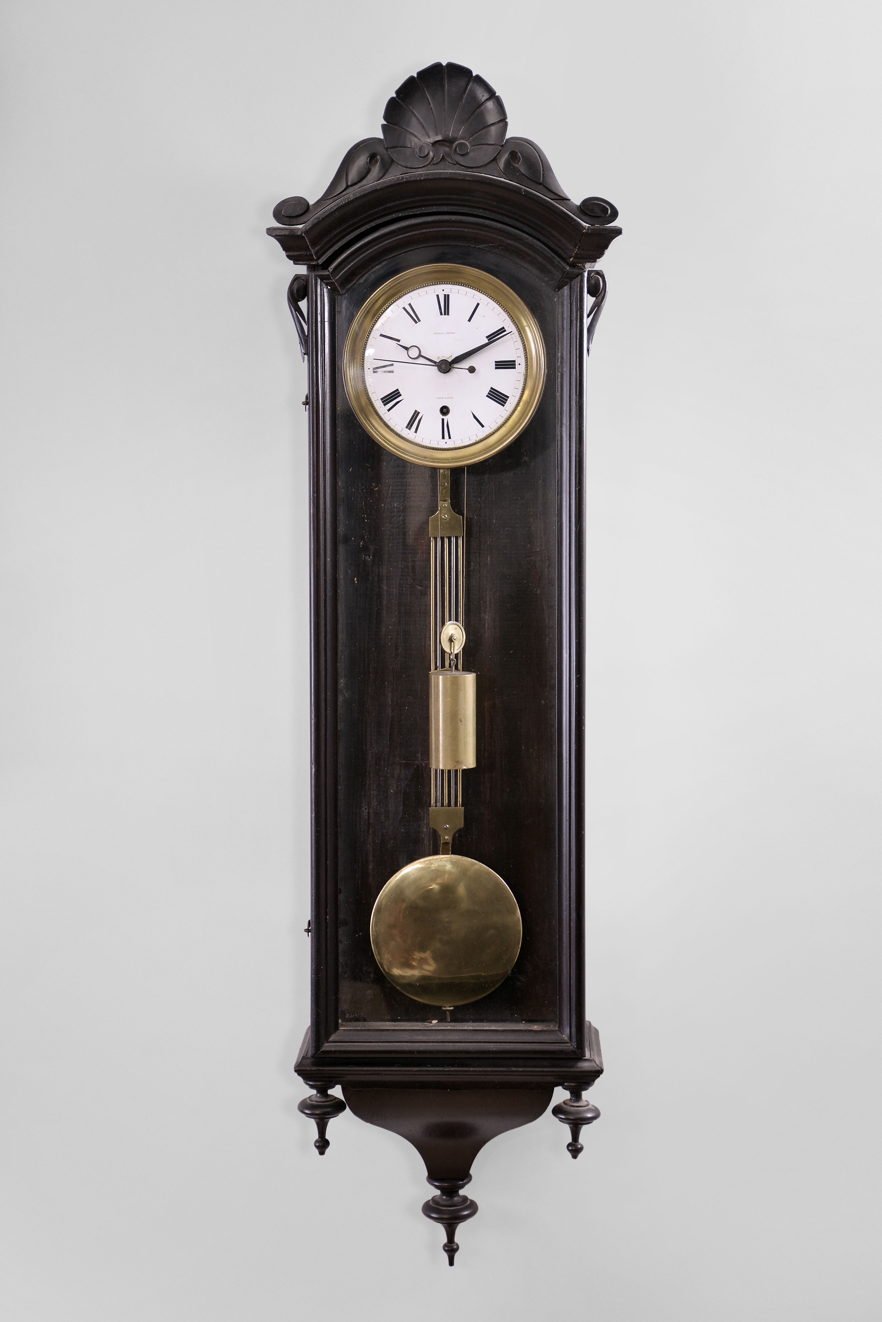 George A. Jones, New York, unidentified model wall hanging regulator with a weight driven 8 day timepiece movement with maintaining power, a sweep second hand and a porcelain dial in an ebonized finished case. — Antique Clocks Price Guide