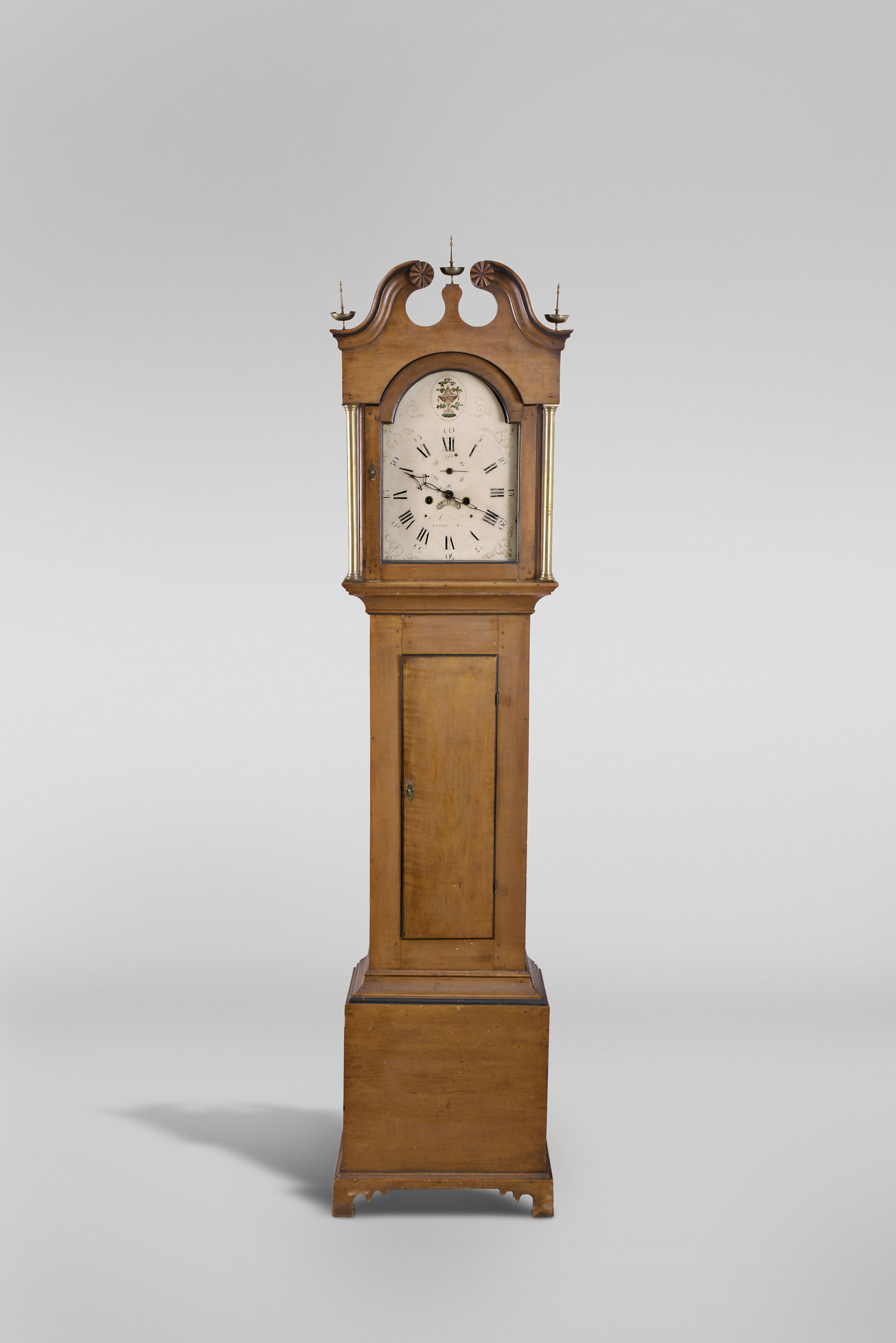 Edward S. Moulton, Rochester, New Hampshire tall clock, 8 day, time and strike, brass weight driven movement in a New Hampshire cherry case with ebonized highlights, broken arch top with carved rosettes, brass finials and straight bracket feet, Roman numeral painted metal dial with seconds bit and calendar — Antique Clocks Price Guide