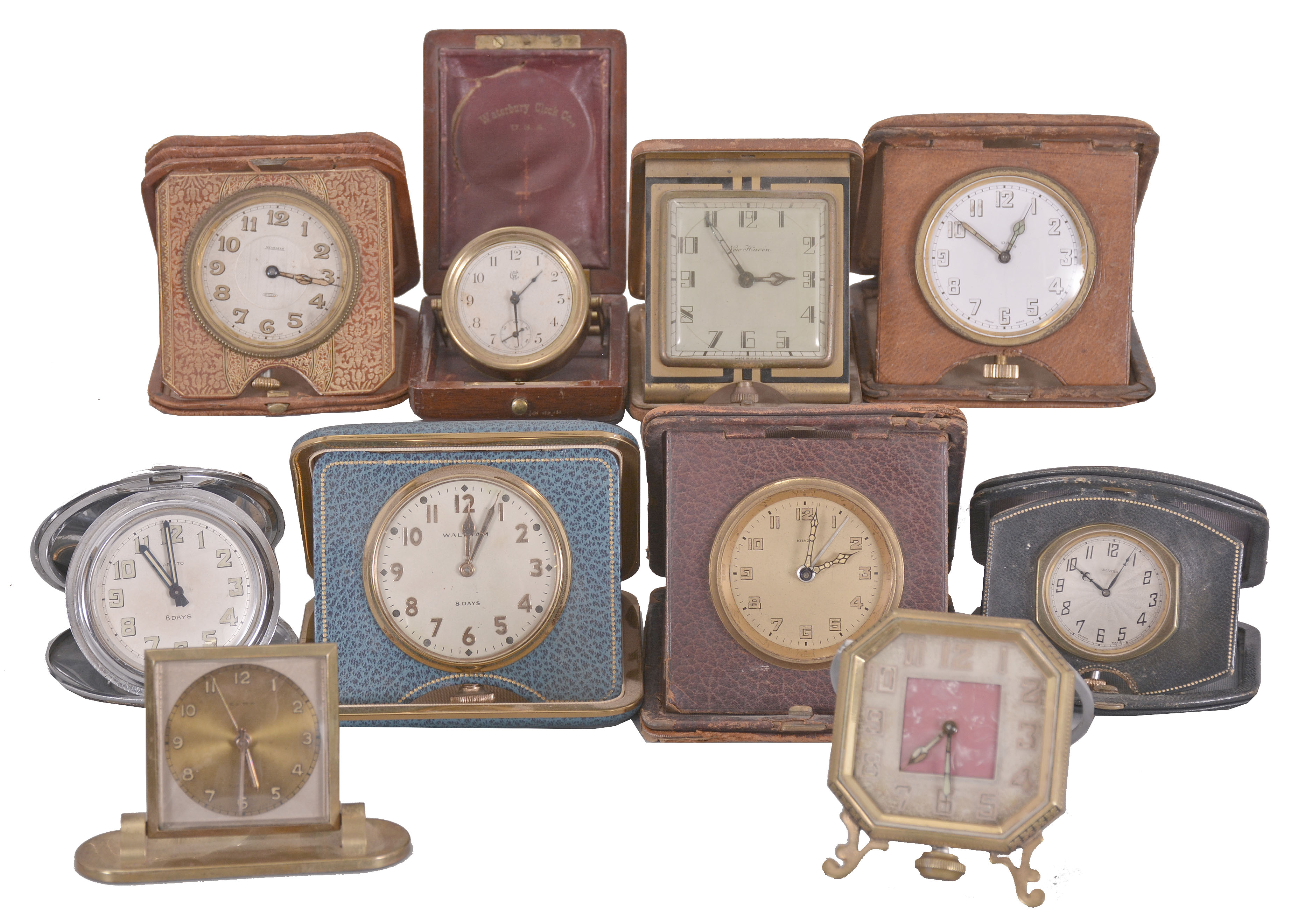 Desk and travel clocks- 10 (Ten), 30 hour and 8 day, Swiss and American, makers including Waltham, New Haven, Waterbury, Keinzle, Normis, and others, most with folding, leather bound cases, one desk clock with octagonal case, easel back, and pink mother of toilet seat center, an unusual Waterbury travel clock with wooden case, and more — Antique Clocks Price Guide