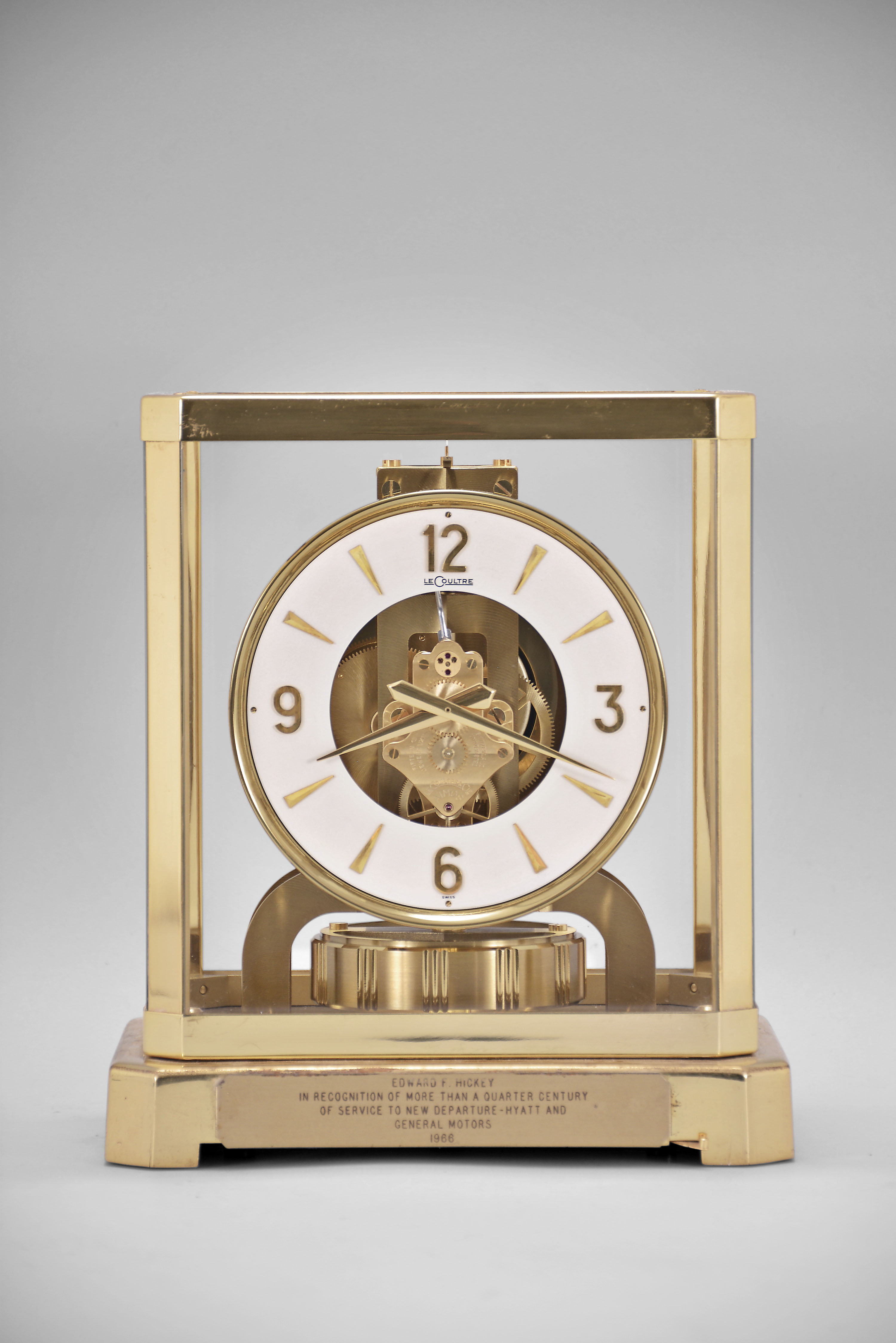 Jaeger-LeCoultre, Switzerland, "Atmos" clock, 15 jewel, caliber 528-8/6 movement, torsion pendulum, round white dial with applied gilt arrow markers and numbers, gilt hands, all contained in a glazed rectangular case with original styrofoam packaging box, serial number 212357. — Antique Clocks Price Guide