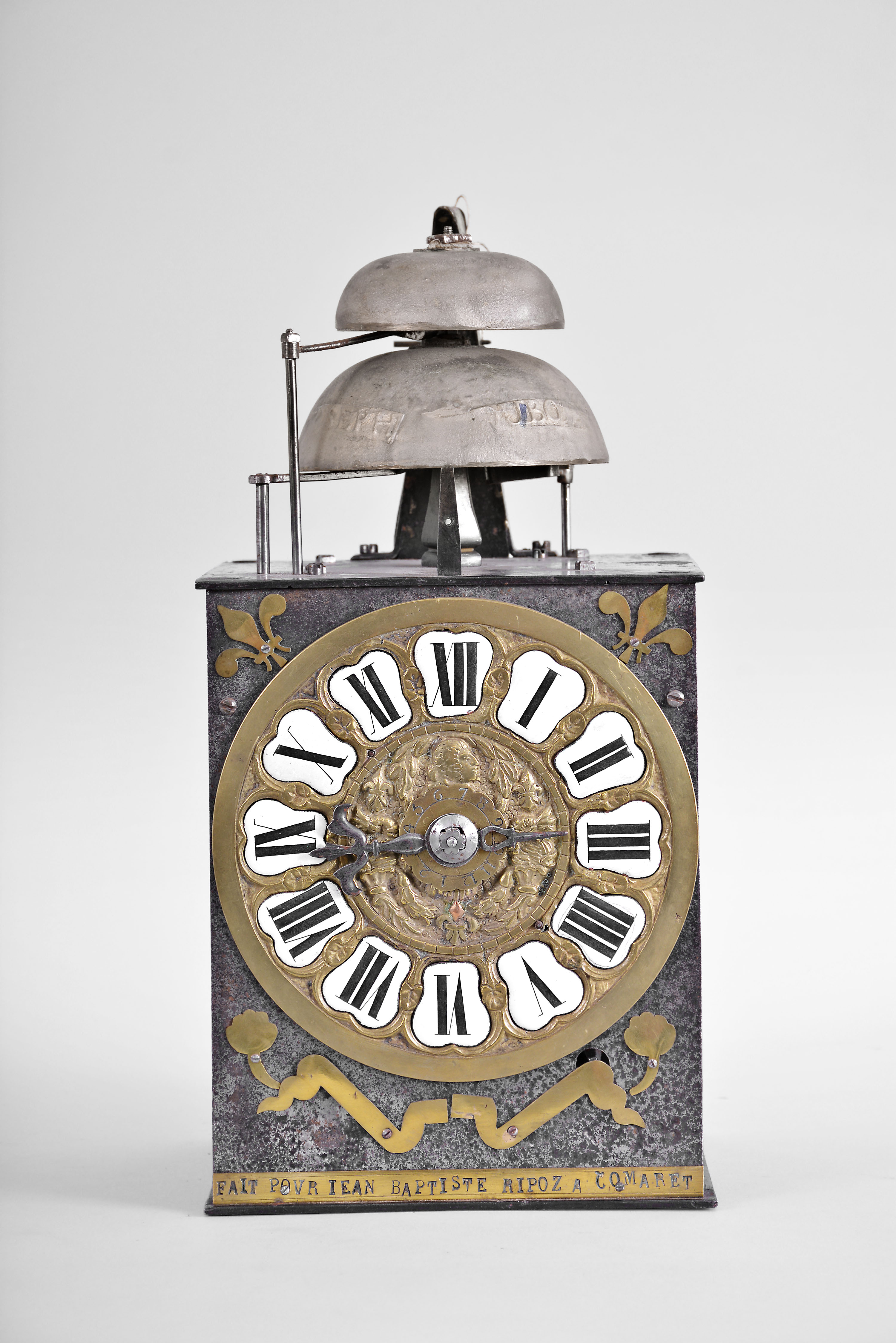 France, Comtoise clock, 8 day, time and strike with alarm, weight driven movement with verge escapement, thread suspension with rear-hanging pendulum in a iron post and plate frame, cast brass dial with a profile of Prince Louis, Dauphin of France surrounded by laurels and fleur de lis, inset white enamel cartouches with Roman numerals, single pierced iron hand, applied brass fleur de lis spandrels above the dial and pivoted winding arbor shutters below, and brass plaque stamped with the words "FAIT POUR JEAN BAPTISTE RIPOZ A COMARET ". — Antique Clocks Price Guide
