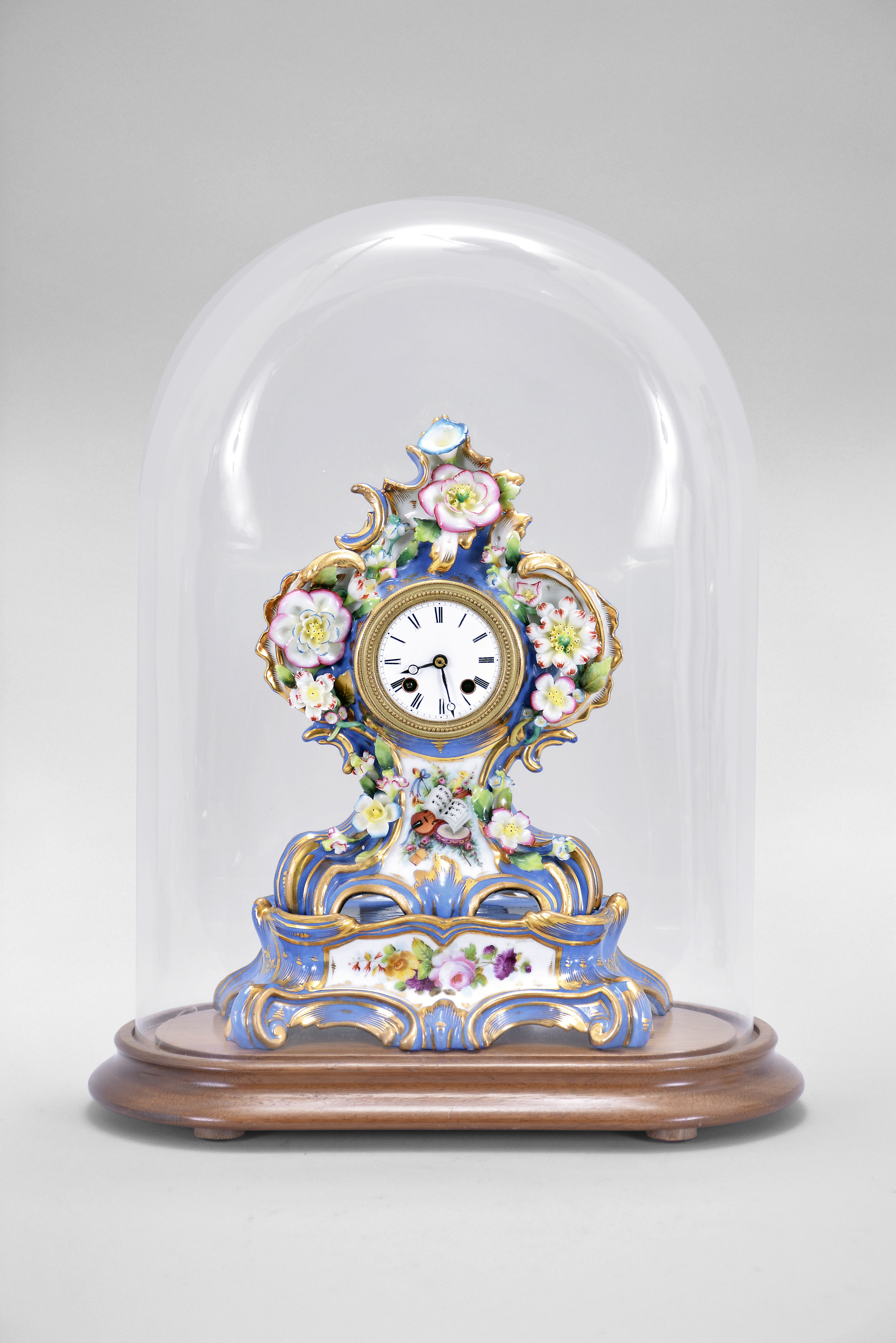 France, two-part porcelain mantel clock, 8 day, time and strike, pendule de Paris movement with silk thread suspension, the case in the style of Jacob Petit, decorated with molded and brightly painted naturalistic ornament, blue ground highlighted by bright gilding, white enamel dial with Roman numerals, Breguet style steel hands, all resting on a wood base under a glass dome — Antique Clocks Price Guide