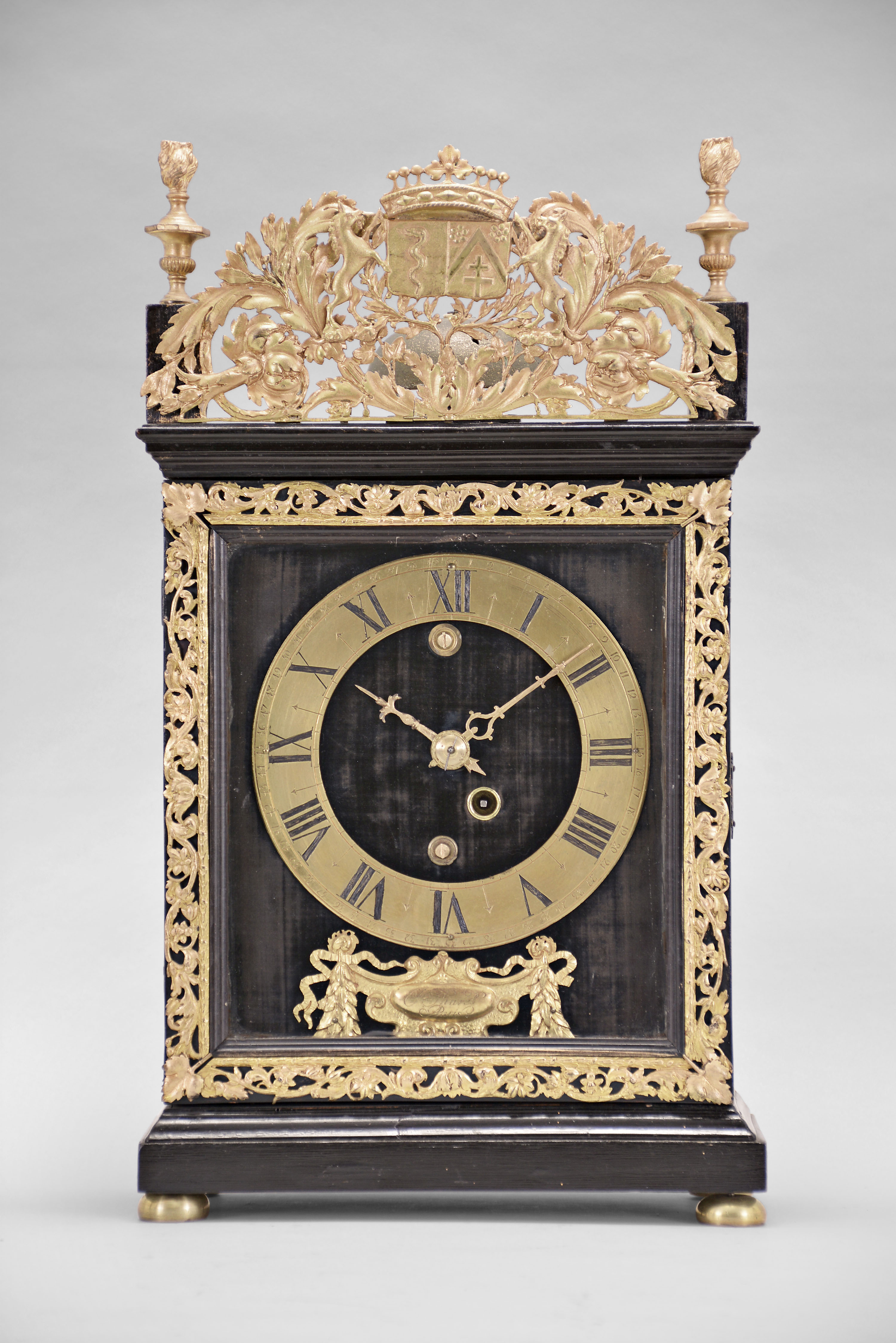 Thuret, a Paris, a 17th century pendule religieuse, the ebonized hardwood case with molded base and cornice, the door with cast, gilt trim, and top finials and cast foliate ornament, with what appears to be a family crest at center, case sides with astragal ended apertures with sliding shutters removable from the top, deep blue velvet lined wooden dial plate, gilt roman numeral dial with Arabic minutes, and gilt mount with laurel and trailing ribbon ornamented cartouche engraved "J. Thuret A Paris", 30 hour two train movement with baluster pillars, powered by a single barrel, and counting the hours on a bell, crown wheel escapement and copper strip suspension with cycloidal cheeks, and decorative, pierced steel levers for strike train warning and locking, and pendulum with turned brass bob — Antique Clocks Price Guide