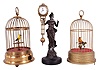 Singing birds- 2 (Two) Singing birds and one swinging mystery clock: German made yellow signing birds in brass cages and one Junghans-style reproduction mystery clock inspired by the "Diana" model.