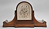 Gebruder Junghans, Schramberg, Germany, mantel clock, 8 day, time and strike with Westminster chime, spring driven movement in a tambour-form mahagony case with an arched silvered dial with Arabic numerals, subsidiary chime/silent selector and rate adjustment, all with with blued steel hands.