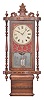 Clocks- 3 (Three): Anglo-American wall clocks, 8 day, time and strike, spring driven brass movements in wood and wood veneer cases with walnut burl, carvings, and/or turned accents, all three with painted metal dials, c1890.