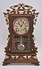 Seth Thomas Clock Co., Thomaston, Conn., "Santa Fe" city series mantel clock, 8 day, time and strike, spring driven movement in a carved walnut case with applied metal leaf decorations.