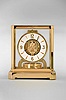Jaeger- LeCoultre, Switzerland, "Atmos" clock, 15 jewel movement, gilt torsion pendulum, round white painted dial with applied gilt Arabic numerals and arrow markers, gilt hands all contained in a glazed rectangular case with removable front panel, serial #245342.