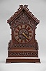 Black Forest, Germany, shelf cuckoo, 50 hour, time and strike with cuckoo bird, spring driven wood plate movement in a wood case with oak veneer on molded feet with stepped chamfered base, trimmed with carved fretwork and applied wood ornaments, bone hands and articulated cuckoo bird with carved feathers, applied Roman numeral dial.