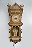 Reproduction Ansonia, "Hanging Antique", 8 day, time and strike, weight driven movement in an oak case with applied brass ornaments, brass dial with enamel cartouche numerals, and blackened steel hands.