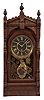 F. Kroeber Clock Co., New York, "Langtry" mantel clock, 8 day, time and strike, spring driven movement in a walnut case with turned side columns and finials, six inch black dial, and Kroeber's patented pendulum.
