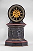 E. Maurice and Co., Paris, France, for Shreve, Crump & Low, Boston, mantel clock, 8 day, time and strike, spring driven pendule de Paris movement with visible Brocot escapement on an molded octagonal base with gilt brass and red marble ovolo molding supporting a central column with the Greek muses cast with relief from patinated metal, supporting a molded octagonal capital upon which rests a drum head of black slate holding the movement, bezel, and polished black slate dial with incised Roman numerals and gilt hands.