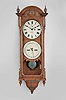 Seth Thomas Clock Co., Thomaston, Conn., "Office Calendar No. 10" hanging clock with a weight driven 8 day timepiece movement, maintaining power, and an R. T. Andrews patented perpetual calendar mechanism in an oak case with burl accents.