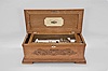 Switzerland for Heeren Bros. and Co., Pittsburgh, Penn., "Ideal Excelsior" interchangeable cylinder music box, 6 tunes using a 9 inch cylinder playing on a one piece comb with 60 teeth, mechanism with Jacot's safety check and speed control in a lidded oak case with molded base and top, applied oak ornament on the front, and retailer label under lid. The lot comes with four 9 inch cylinders which come in a matching oak case.