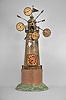 Gebruder Junghans AG, Schramberg, Germany, "World Time Clock", 8 day, time only, spring driven pendulum movement in a metal case taking the form of a windmill, a primary clock dial in the base and subsidiary dials radiating from the top showing times for other locations on the globe including Paris, Peking, Amsterdam, Petersburg.