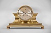 Chelsea Clock Co., Boston, Mass., "Tambour No. 1" mantel clock, 8 day, time and house strike, spring driven balance wheel movement with lever escapement in a polished brass case on ball feet with a six inch silvered dial and applied brass numerals.