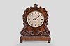 Connell, Late Ganthony, 83 Cheapside, London, a large, mid 19th century mahogany bracket clock, rectangular molded base with compressed ball feet, the case front with applied carved foliate ornaments with scrolls terminating in pendant husks, and with carved C and S scrolls flanking and above the silvered roman numeral dial, the case sides conforming to the contours of the carved elements, back with fabric lined door and fine mahogany fret, blued steel pierced spade hands, two train fusee movement with recoil escapement, counting the hours on a bell