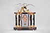 Michel Decoux, a marble and polished metal mantel clock with gull ornament, the oblong base and top with brown, variegated marble veneers over contrasting black slate base and panels, joined portico style by six hexagonal, polished chrome columns with polished, gilt capitals and bases, and flanking a polished chrome crystal regulator case, surmounted by a polished, gilt wave form casting and polished chrome gull, signed "Decoux", diamond shaped Arabic numeral metal dial with blued steel hands, and 8 day Pendule de Paris movement, striking on a bell