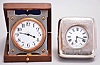 Travel clocks- 2 (Two): the first marked "Barbezat Swiss", 15 jewel, quarter repeating cotes de Geneve decorated nickel movement with arabic numeral white enamel dial, mounted to a folding sterling silver plate and hinged to a mahogany box, the top with applied foliate ornament surrounding a knight's mask and crown, above an oblong enamel panel set with a gold castle tower ornament, the other with 7 jewel Swiss movement marked "Venta", roman numeral white enamel dial, and silver open face case, contained in an easel back, leather clad, velvet lined box, the front mounted with sterling silver and engraved with floral drops, garlands, and bow knots, with London hallmark, and date letter for the year 1908