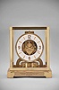 Jaeger-LeCoultre, Switzerland, "Atmos" clock, 15 jewel, caliber 528-8/6 movement, torsion pendulum, round white dial with applied gilt arrow markers and numbers, gilt hands, all contained in a glazed rectangular case with original styrofoam packaging box, serial number 212357.