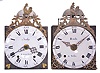 Clocks- 2 (Two) Comtoise wall clocks: (1) France, bronze-front Comtoise wall clock, 8 day, time and strike, weight driven movement with verge escapement, thread suspension with rear-hanging pendulum in an iron post and plate frame, early enamel dial with concave center and convex chapter, Roman numerals for the hours, large Arabic numerals at 5 minute intervals, signed "Bailly a Marcigny", cast bronze fronton with backward facing Gallic rooster above a medallion with three hearts which replace the royal fleur de lis found in the same location on earlier clocks, two applied heart shaped spandrels below the dial, and iron hands, late 18th Century. (2) France, bronze-front Comtoise wall clock, 8 day, time and strike, weight driven movement with alarm, verge escapement, thread suspension with rear-hanging pendulum in an iron post and plate frame, early glazed tin glazed earthenware dial with concave center and convex chapter, Roman numerals for the hours, large Arabic numerals at 5 minute intervals, signed "Bondie a Tullin", cast bronze fronton with backward facing Gallic rooster above a medallion with the word "Liberte", two applied spandrels, end of 18th Century.