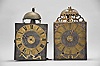 Clocks- 2 (Two) Early Comtoise: (1) France, Comtoise clock, 8 day, time and strike, weight driven movement with verge escapement, thread suspension with rear-hanging pendulum in a iron post and plate frame, brass chapter ring with engraved Roman numerals, pivoted winding arbor shutters, and single iron hand, first half of the 18th Century. (2) France, Comtoise clock, 8 day, time and strike with alarm sounding on a second bell, weight driven movement with verge escapement, thread suspension with rear-hanging pendulum in a iron post and plate frame, brass chapter ring with engraved Roman numerals, applied brass spandrels and pivoted winding arbor shutters, and single brass hand, first half of the 18th Century.