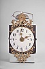 France, Restoration Period bronze-front Comtoise clock, 8 day, time and strike with alarm, weight driven movement with rear winding arbors, verge escapement with thread suspension and front-hanging pendulum in an iron posted frame, convex faience dial with Arabic numerals for the hours and smaller numerals at 15 minute intervals, alarm ring with Arabic numerals, two brass hands with sun bursts, cast brass fronton with central sun image above a single fleur de lis and flanked by putti, lower fronton casting with flowers and fleur de lis.