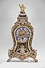 LeRoy, a Paris, a small Contre- Partie Boulle bracket clock with pull repeat, the case with polychrome, naturalistic ornament set into the brass veneer, the base with central mask, scroll feet, and foliate mounts conforming to the curves of the case, kidney shape, molded brass door with leaf and shell ornament, gadrooned brass cornice terminating in leaf and scroll mounts, and with central shell, the removable pagoda top surmounted by a seated figure of a small boy, in his left hand an hourglass with wings, and his right arm raised, the top concealing three bells, signed brass dial with Roman numeral enamel cartouches, finely finished blued steel hands, signed brass movement with tapered baluster form pillars, large barrel and five wheel train, crown wheel escapement, and sounding the last hour and quarter by pulling a cord, all resting on a matching, incurved bracket