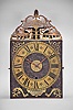 F. Farjaire, Saint-atienne, France, three train Comtoise clock, 8 day, time and quarter strike with alarm, three bells, weight driven movement with verge escapement, thread suspension with rear-hanging pendulum in an iron post and plate frame, brass chapter with Roman numerals, Arabic numerals at 5 minute intervals on the outer rim, brass alarm ring with Arabic numerals, two iron hands, pivoted brass winding arbor shutters, engraved plaque with the maker's name, all topped by pierced brass fronton.