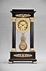 France, Empire portico clock, 8 day, time and strike, spring driven pendule de Paris movement in a polished black slate case on cast brass feet, the base and top with applied gilt rose ornaments, four Corinthian columns with gilt bases and capitals, the gilt bezel with repeating acanthus leaf design, gilt chapter ring with Roman numerals, cast dial center and gridiron pendulum both with floral designs, blued steel Breguet hands.