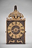 France, Comtoise clock, 8 day, time and strike with alarm, weight driven movement with verge escapement, thread suspension with rear-hanging pendulum in a iron post and plate frame, brass chapter ring with engraved Roman numerals, brass alarm ring with engraved Arabic numerals, pivoted winding arbor shutters, single pierced brass hand, the top with pierced brass fronton.