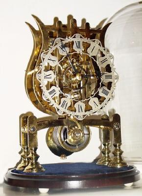 Mid 20th Century, English, Passing Strike Skeleton clock in a lyre style frame with engraving on the front plate. — Antique Clocks Price Guide